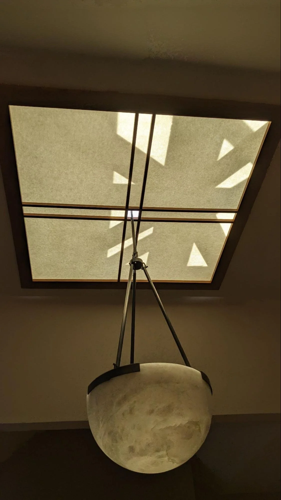 Skylight framework shadows move across the shoji