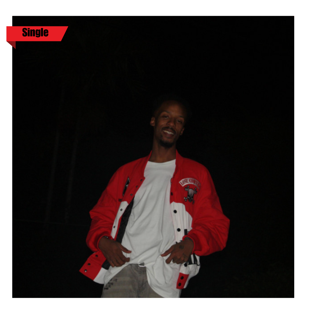 A young man standing outdoors at night, smiling, wearing a red and white varsity jacket and a white T-shirt.