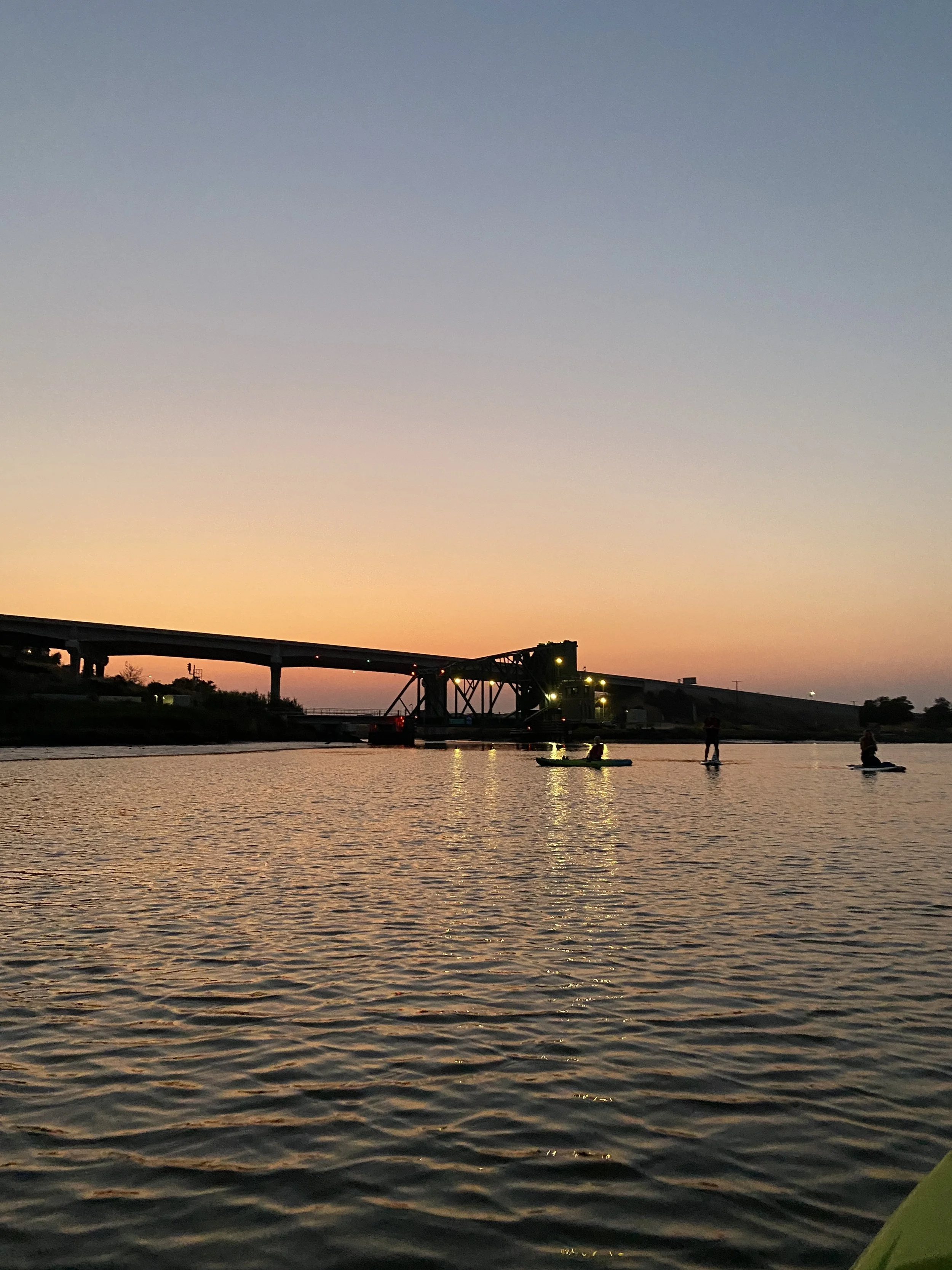 A full moon paddle from The Floathouse Petaluma in downtown Petaluma, 2024. The SMART Railroad bridge and Highway 101 bridge are in the background. 
