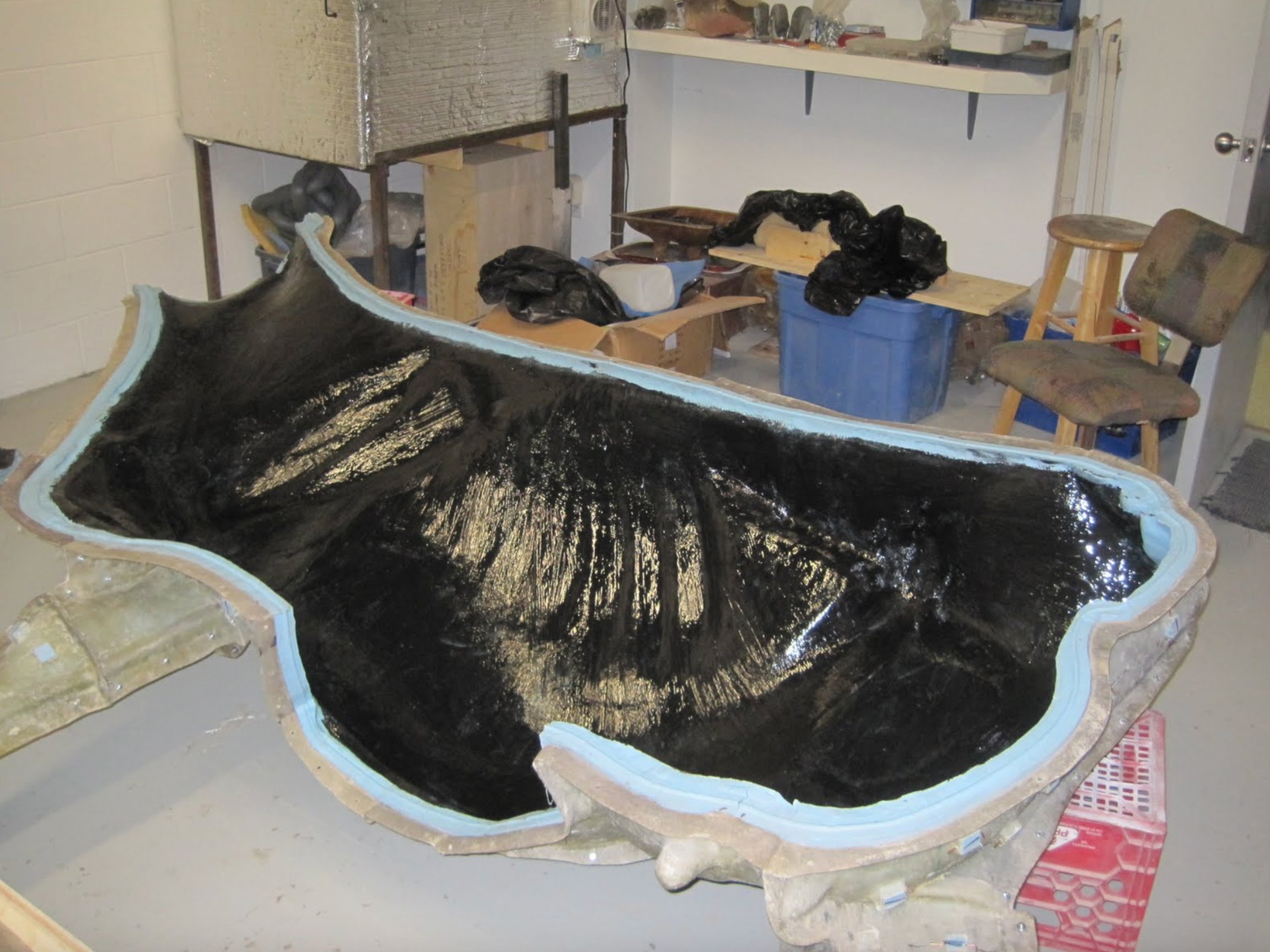  One side of the Holstein mold, with the first layer of epoxy resin applied. Several more layers of fiberglass will be applied, infused with epoxy resin. The two halves will then be joined together to complete the body. 
