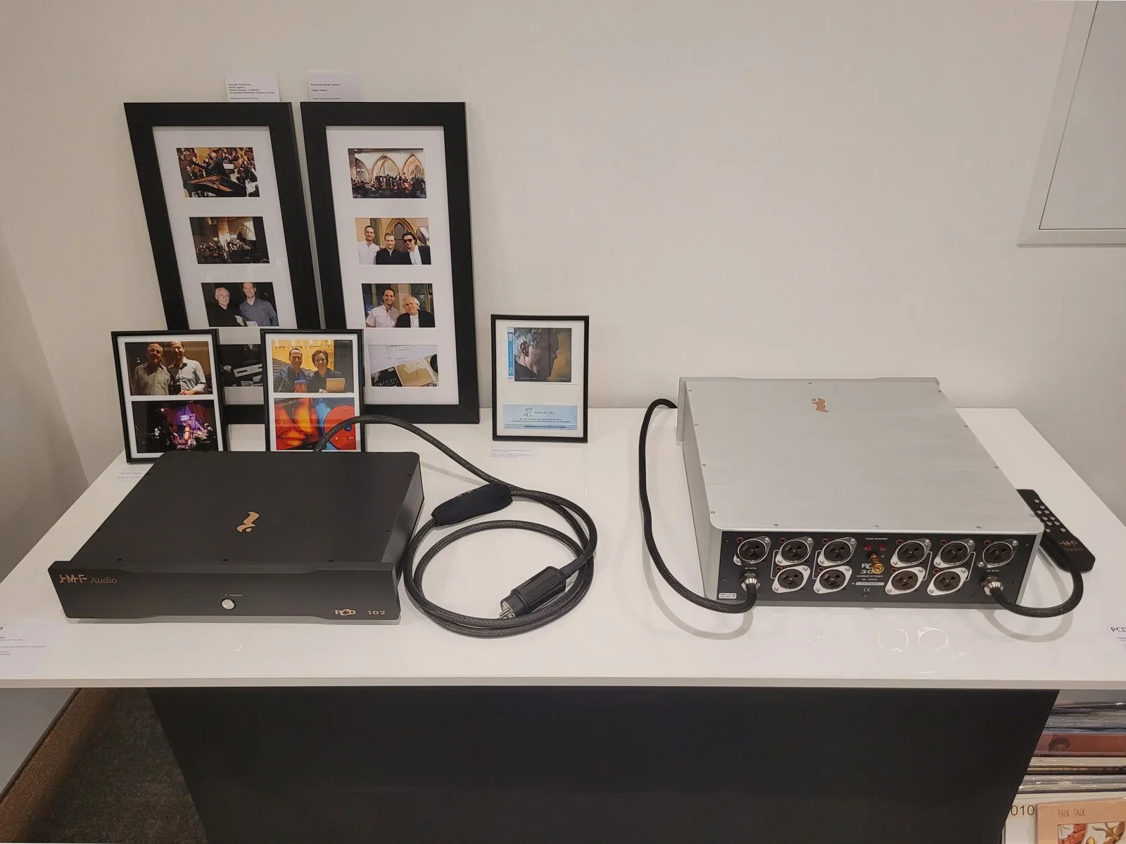 The PCD 102 and PCD 302 mains filtering solutions with their attached PC3 cords. Orose® black and silver enclosures. 
In the background, a display of the first recording ever produced  with the JMF Audio PCD 302, Jan Gunnar Hoff "Stories", by Morten 