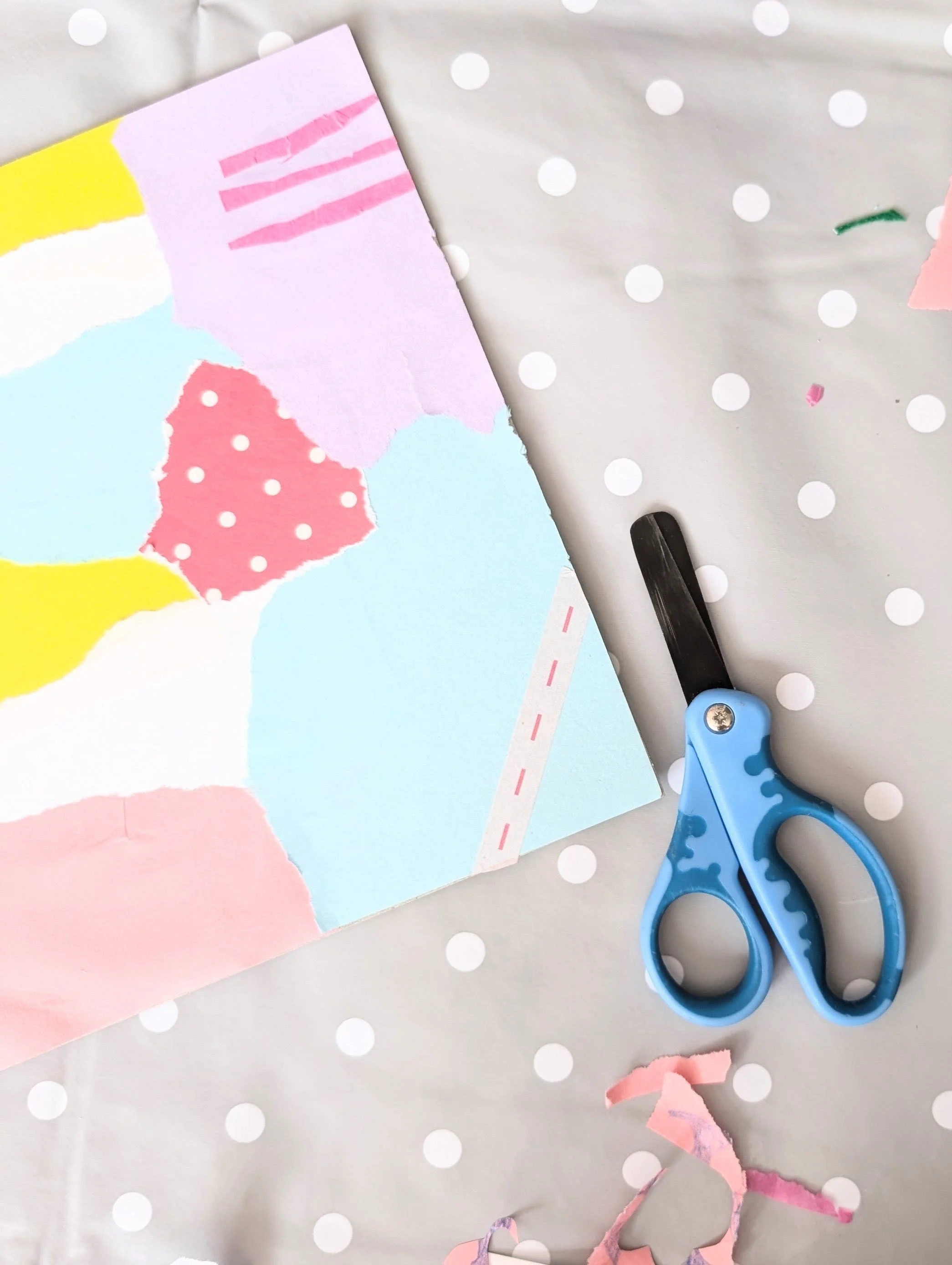 Colourful paper collage with scissors nearby.