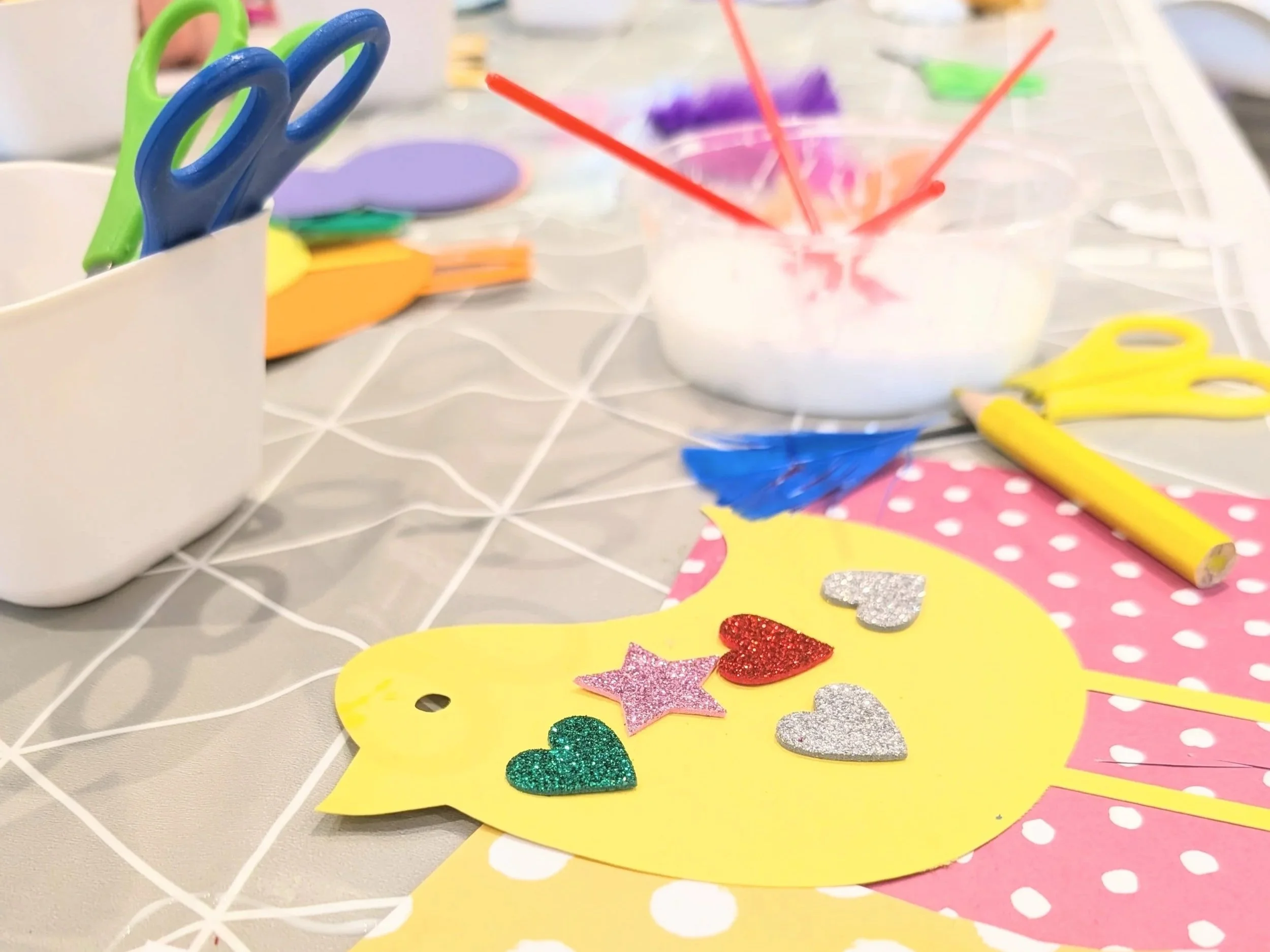 cardboard bird being decorated with various craft materials.