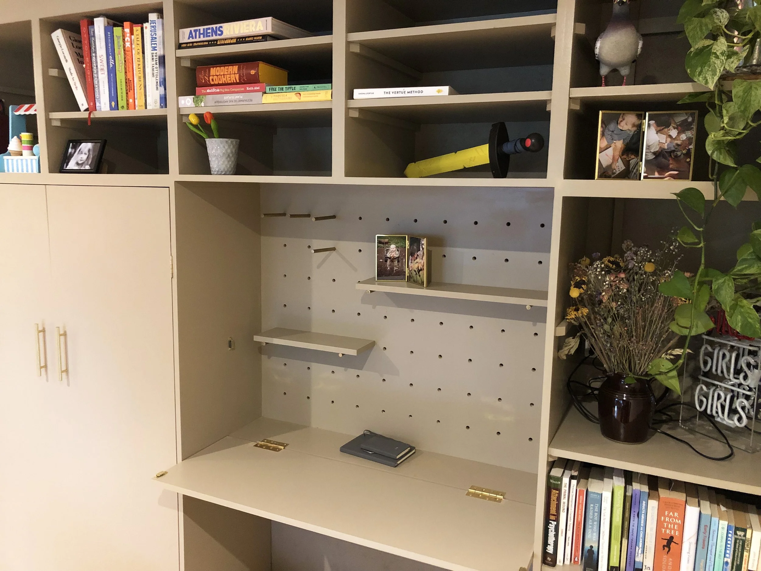 Study & storage area with a fold out desk and peg board.