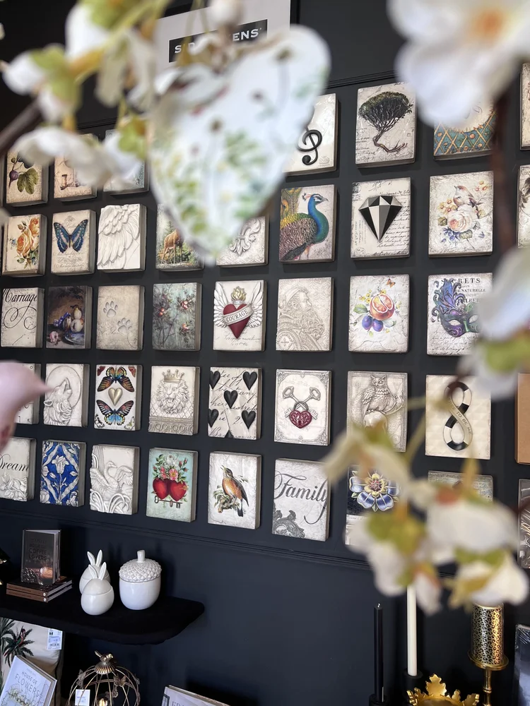 A wall of Sid Dickens Memory Blocks at Hudson Belle, with a peacock, a butterfly, a heart and flowers
