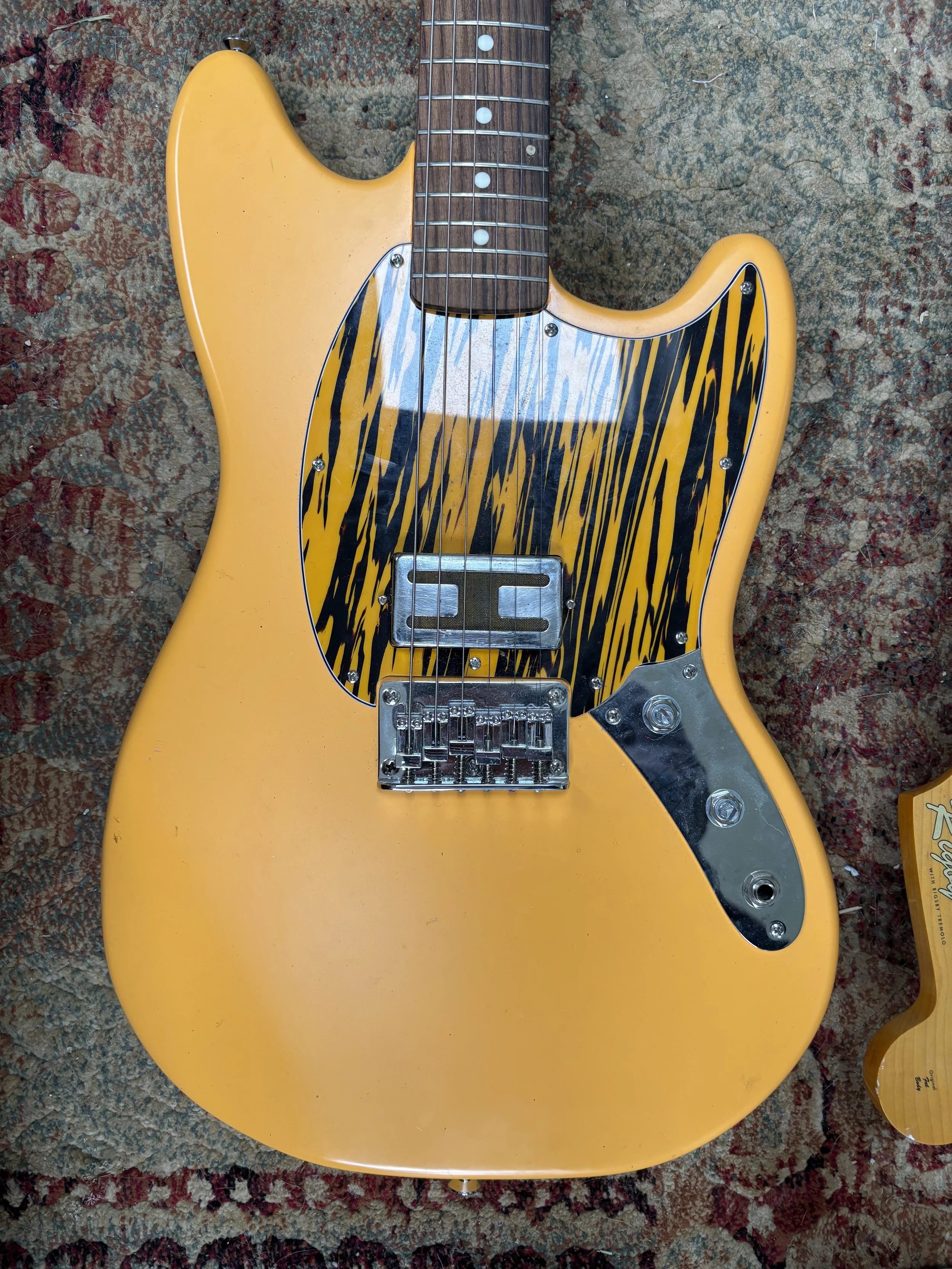 Mustard yellow fender style offset, like a mustang with greens humbucker pickup, yellow and black tiger style pickguard