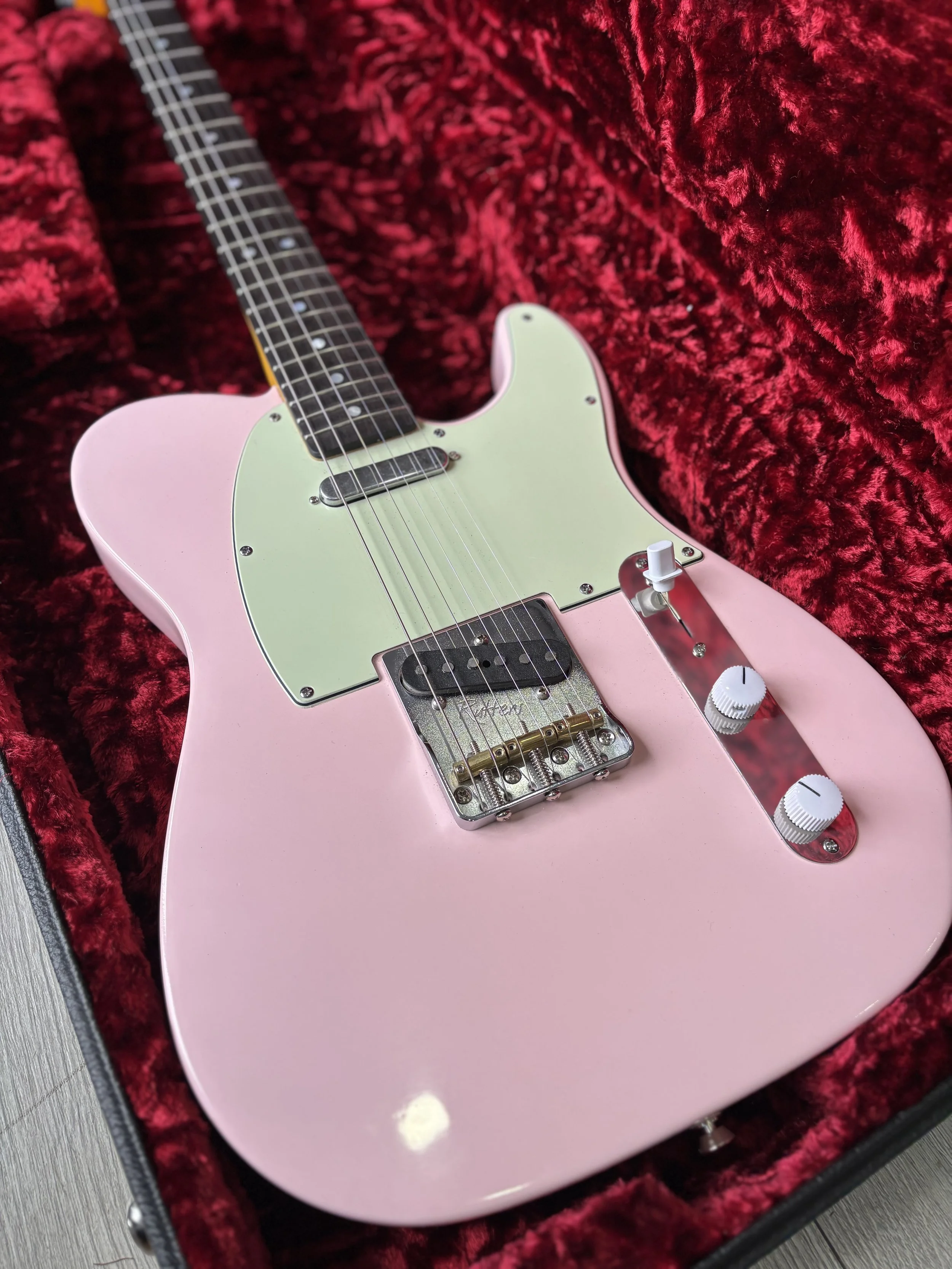 pink telecaster like fender, white pickguard, rosewood neck