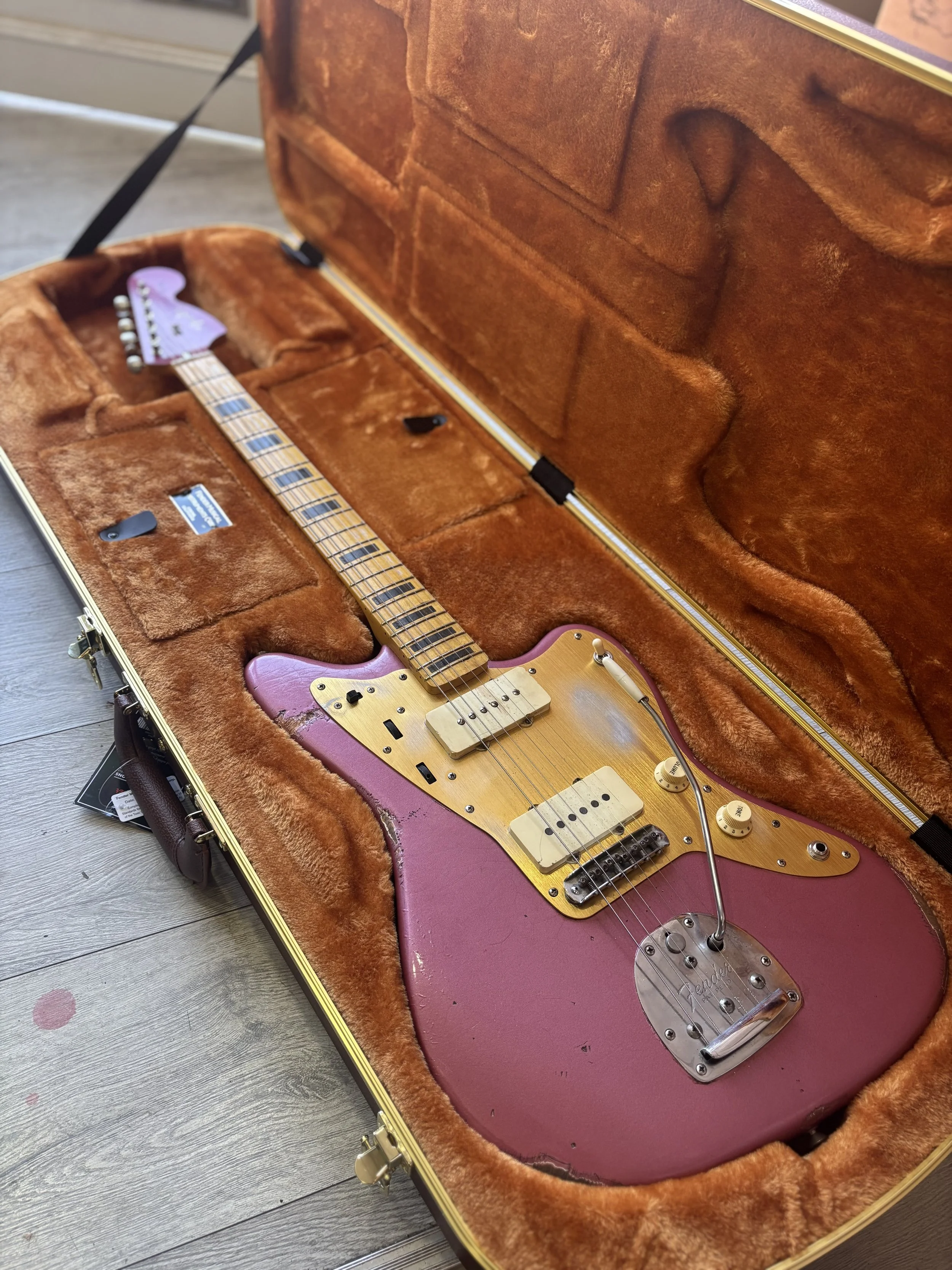 pink jazzmaster, gold scratchplate, block inlay maple neck and matching headstock.