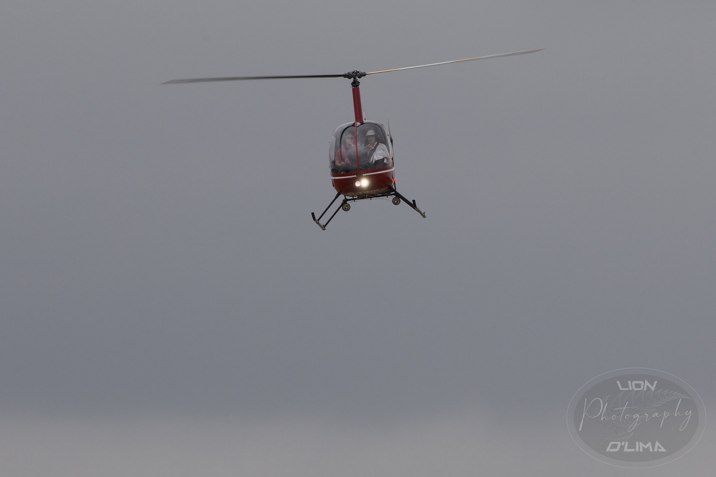 A Robinson R22 Helicopter just about to land with it’s landing lights on at Beccles Airfield in Norfolk - England
