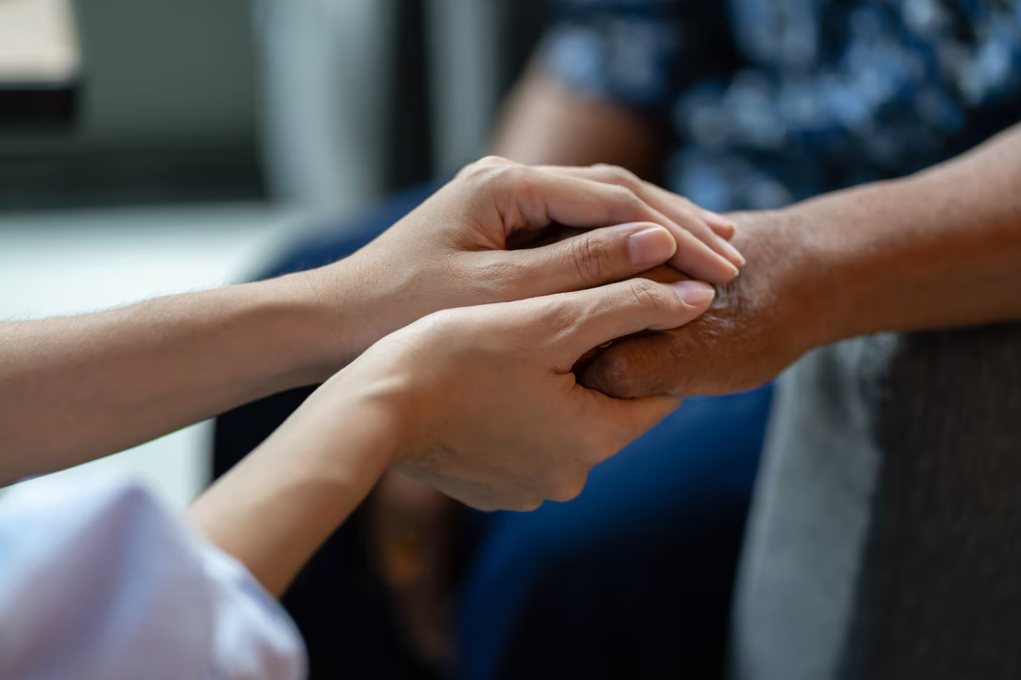 Two hands holding a third hand.