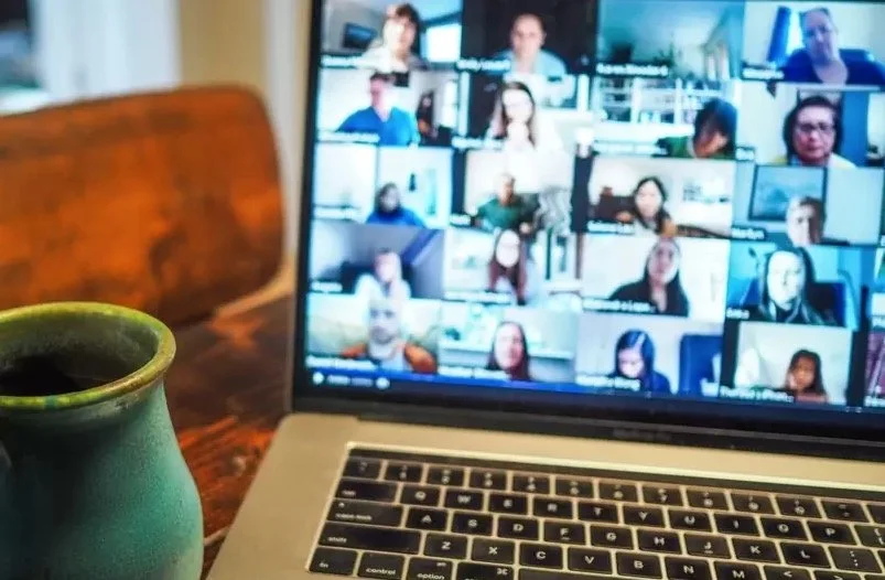 Laptop with blurred focus with screen containing a large video call.