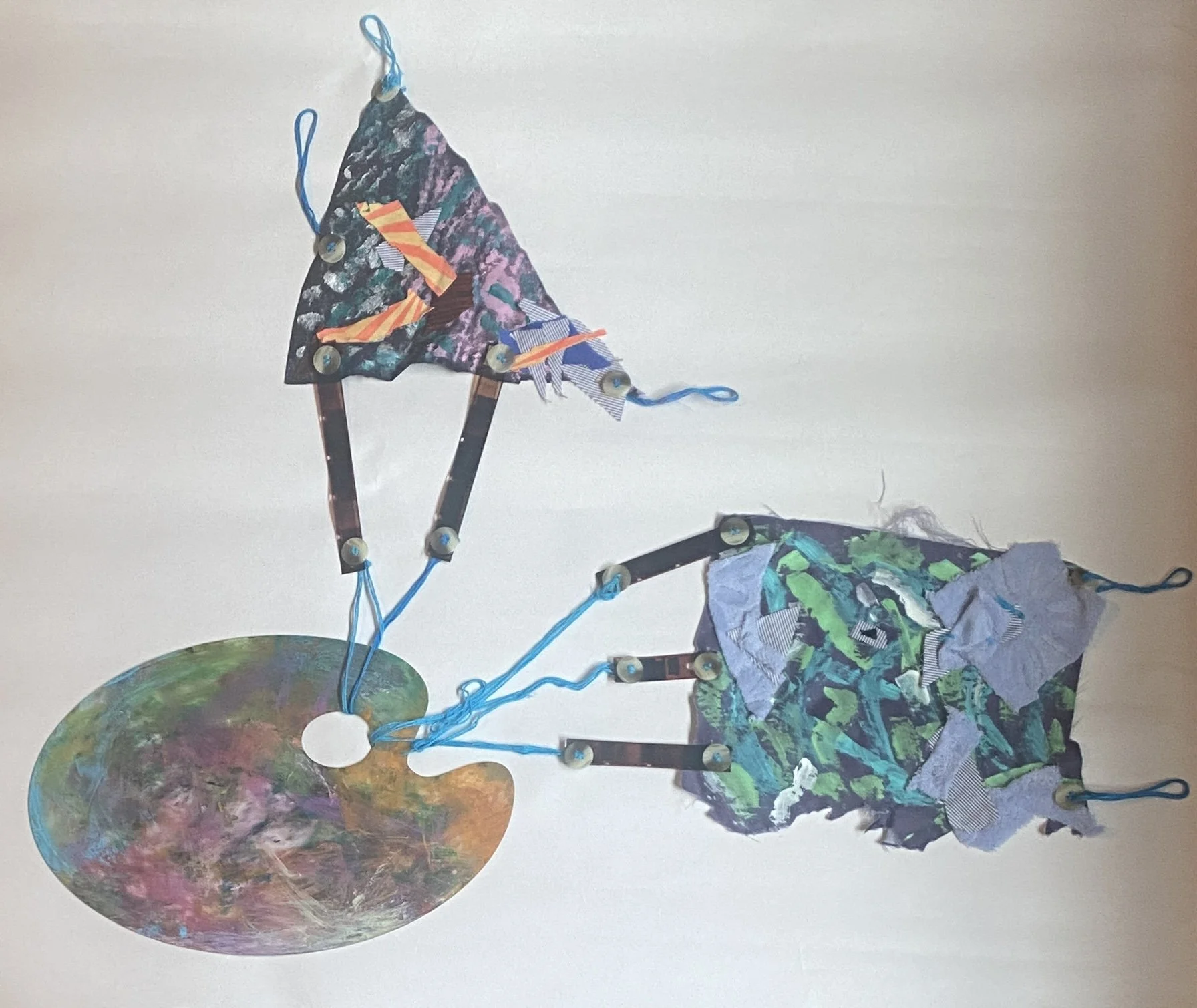 Spinning Tales #1 (Series), 2023. Acrylic paint, recycled fabric and buttons, embroidery floss, palette, and film negatives, 25" x 21".