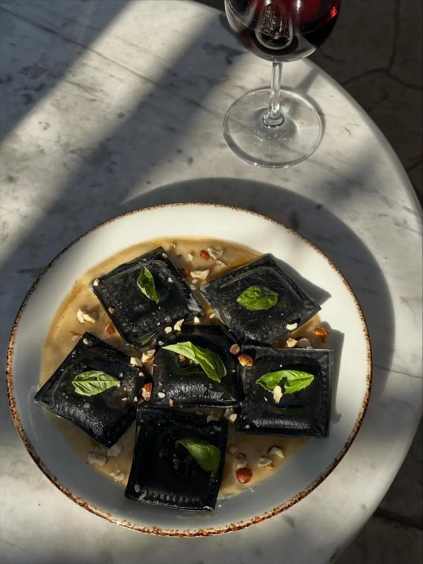 Pasta Party special for tonight! Squid ink ravioli filled with seasoned  pumpkin puree, parmesan cream sauce. Infused herbed brown butter, toasted hazelnut and basil 🦇🎃