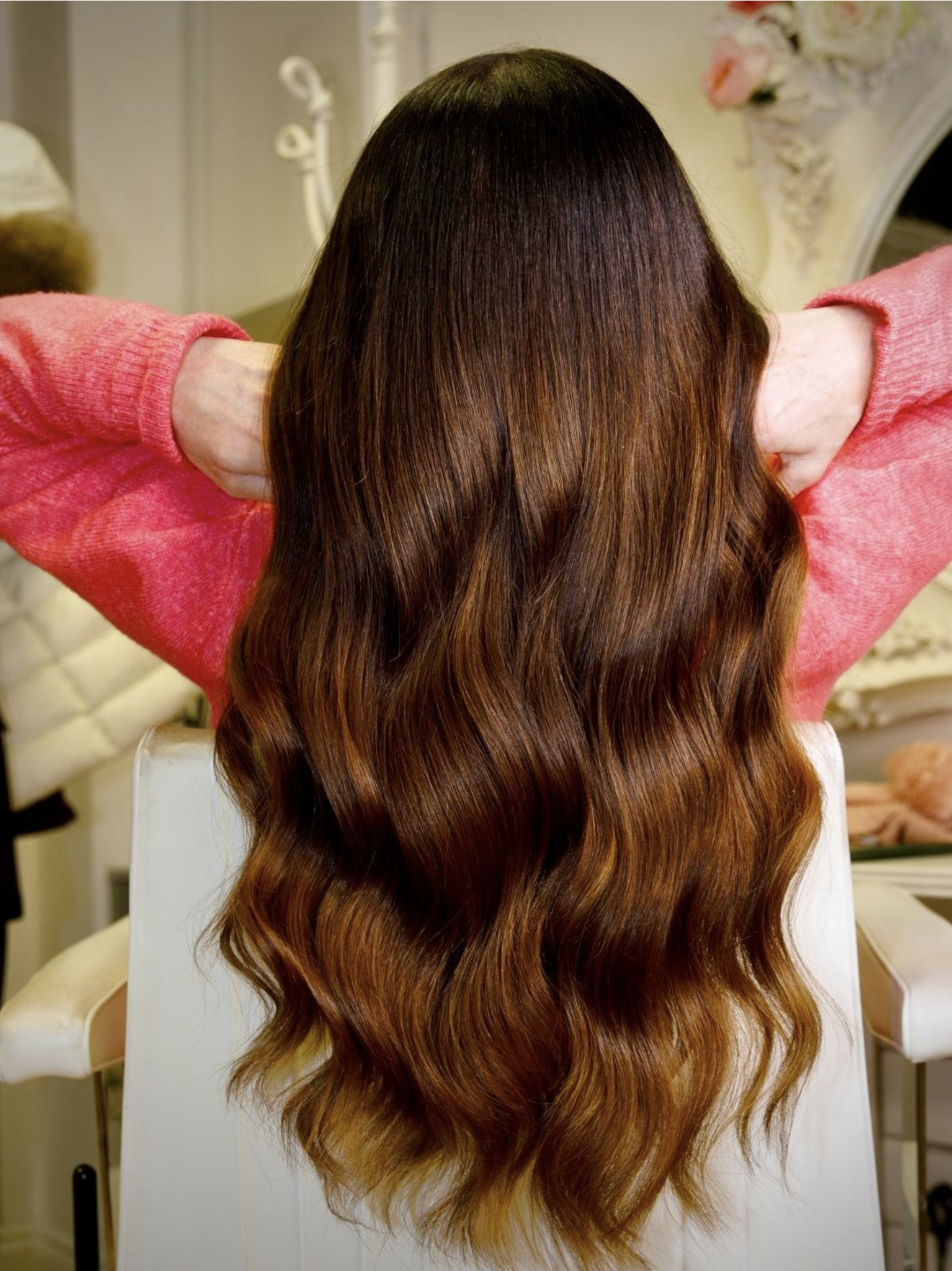 Rich brunette extensions with long, glossy waves.