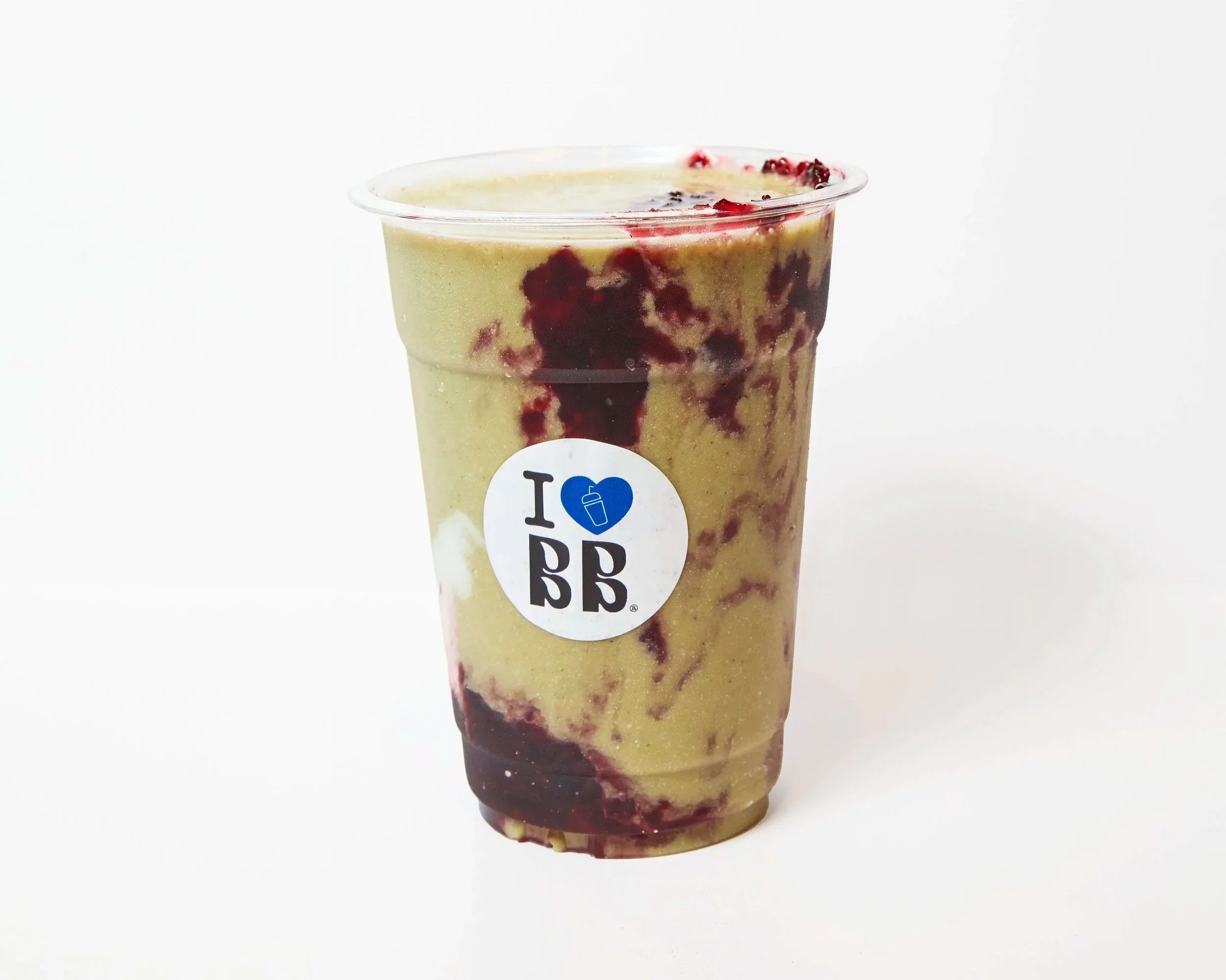 A plastic cup filled with a creamy smoothie that has swirls of red fruit sauce on top and throughout, with a white label featuring a blue heart and black text.