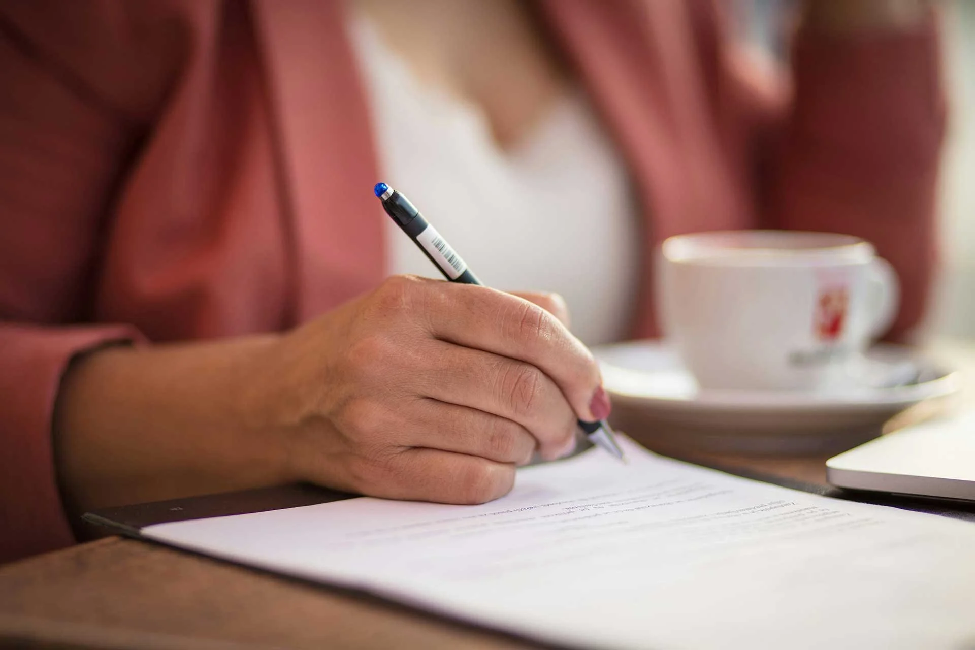 Close-up of a woman writing on a worksheet in a private co-parenting session