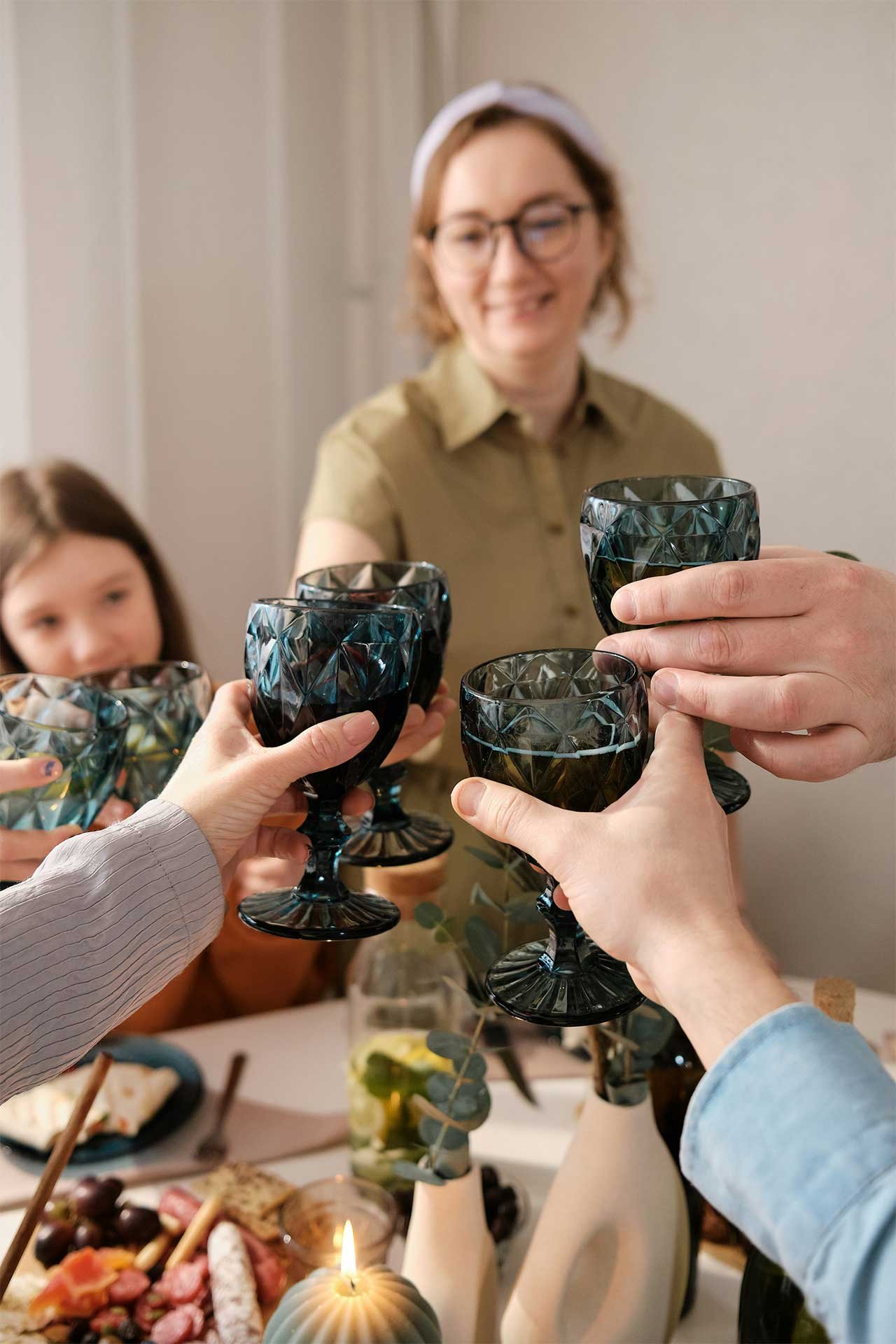 Family raising glasses together around a table, sharing a positive moment of connection.