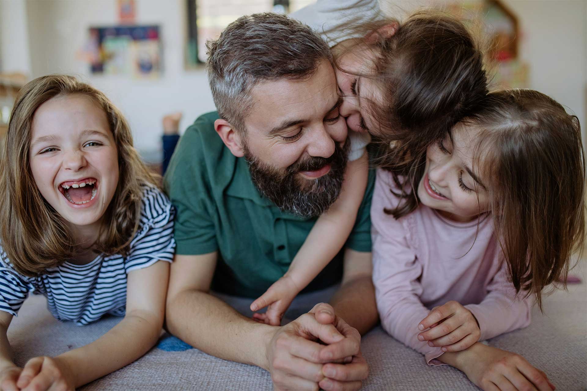 Single father sharing a warm, affectionate moment at home with his children