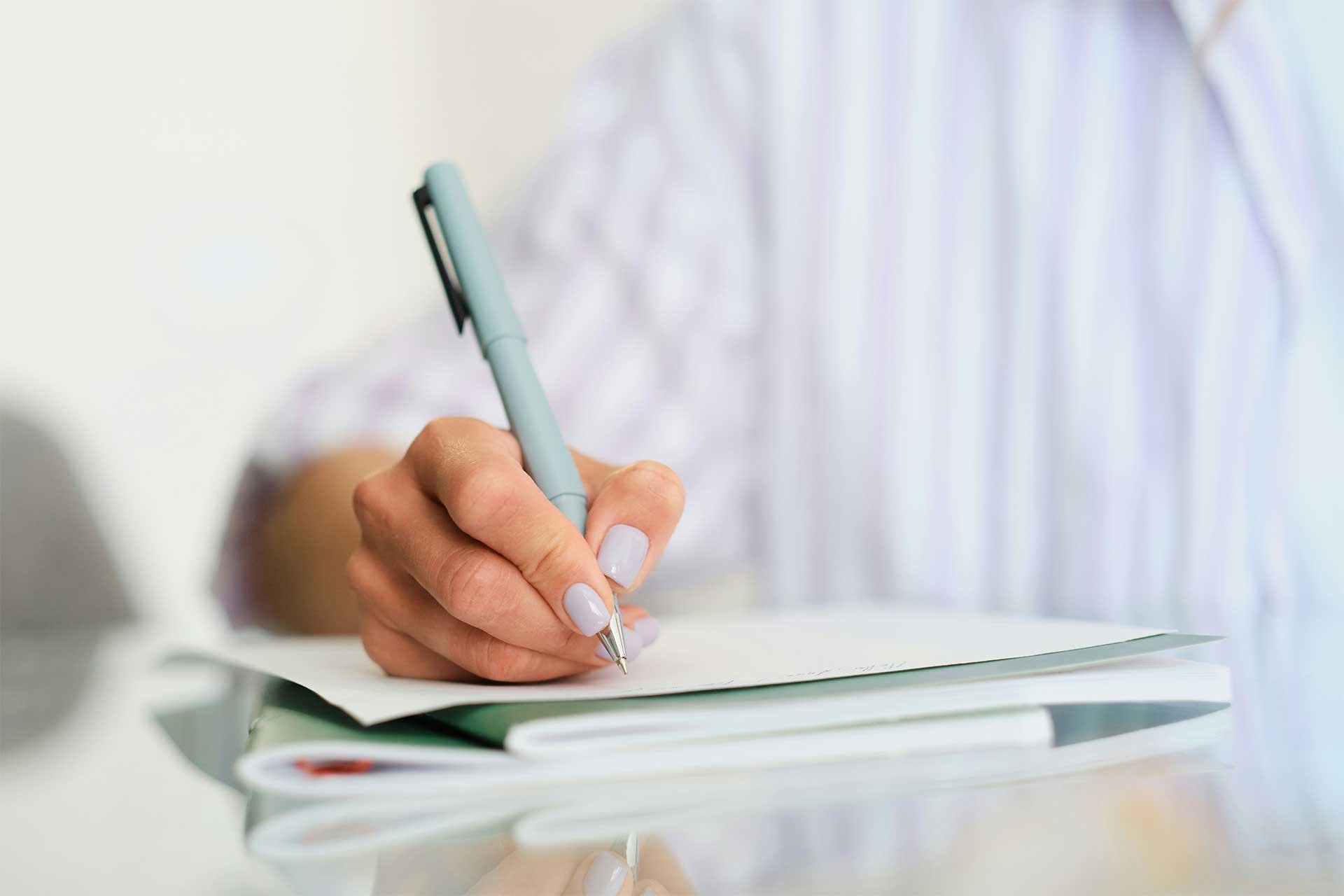Close-up of a person writing in a notebook