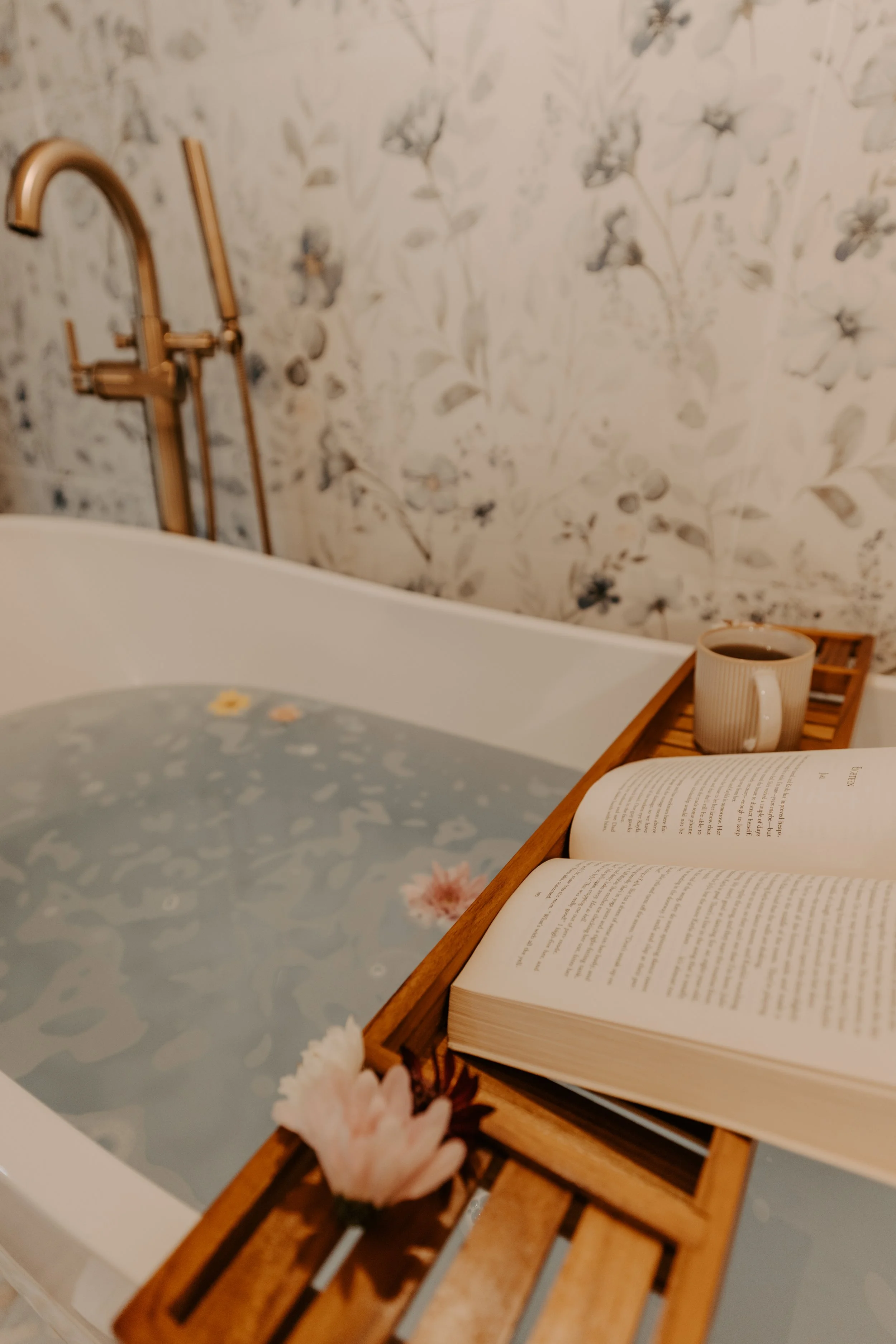 Luxury Soaking Tub with flower petals and book and coffee