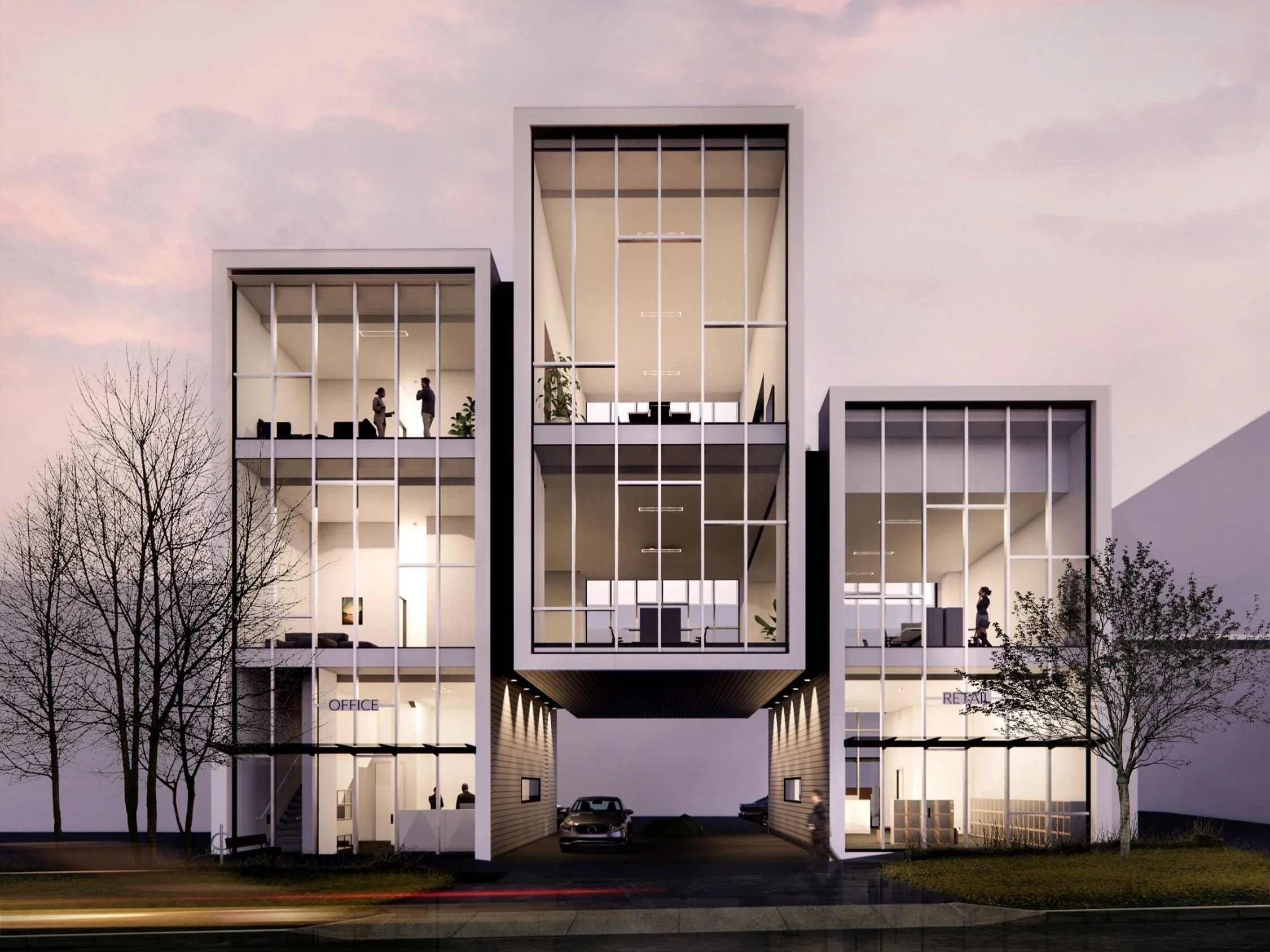 A modern multi-story office and retail building with glass facades, trees in front, and people inside and outside, during dusk.