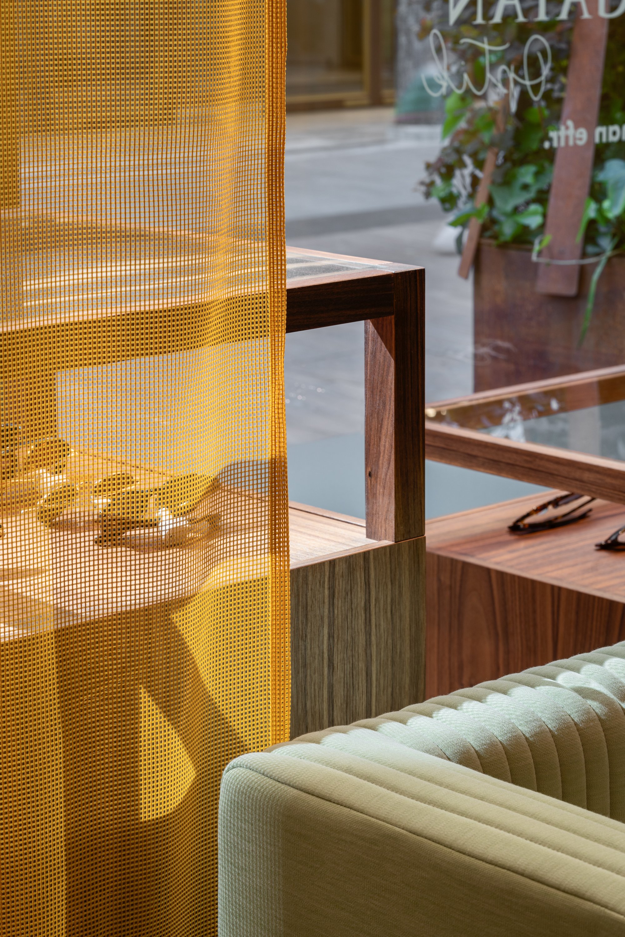 Fredsgatan Optik eyewear store in Gothenburg by Studio Navet — soft colourful textile backdrop with custom mirrors and display cabinets.