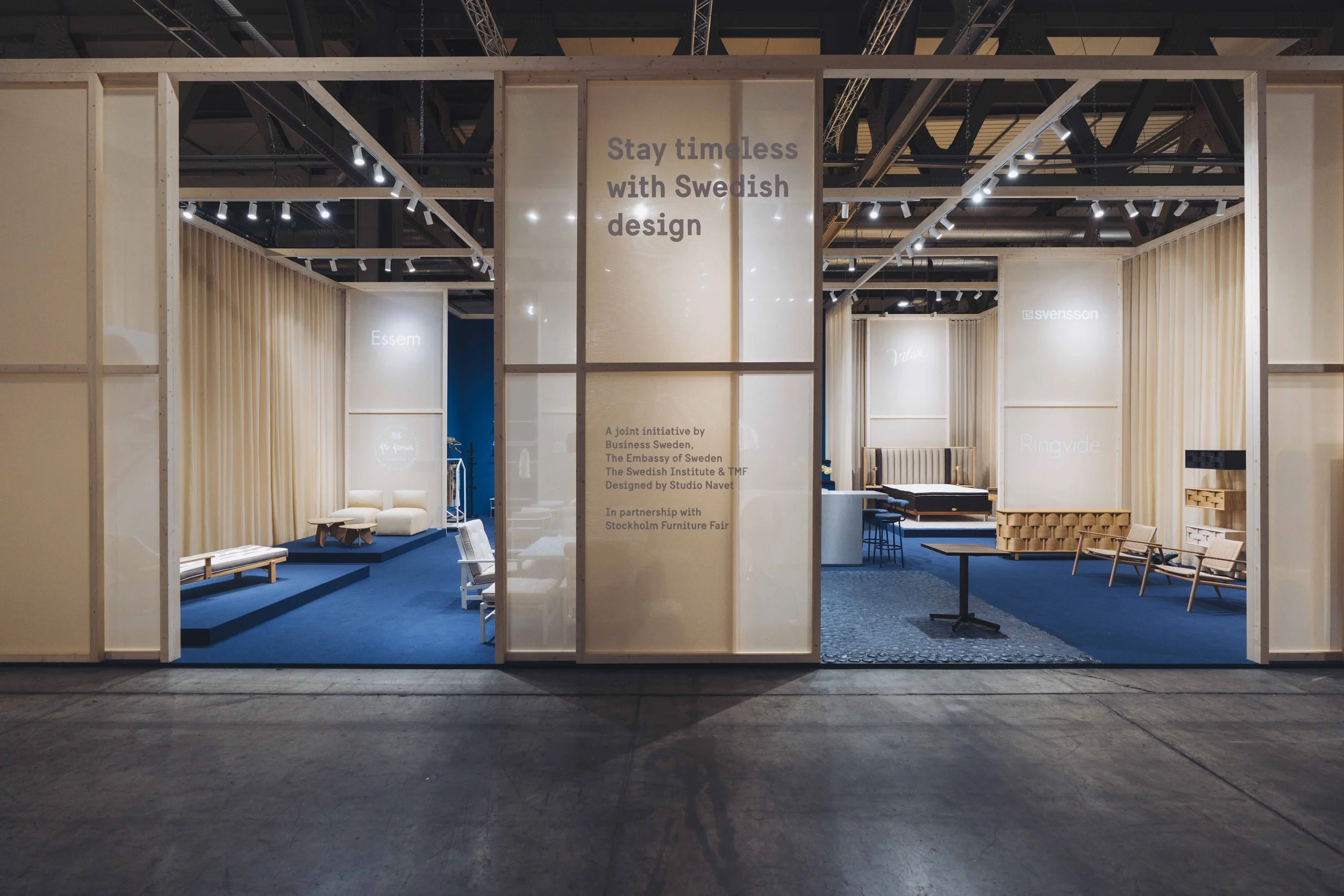 Stay Timeless with Swedish Design exhibition at Salone del Mobile, Milan, by Studio Navet — wooden structure and sheer fabric against a deep blue base.