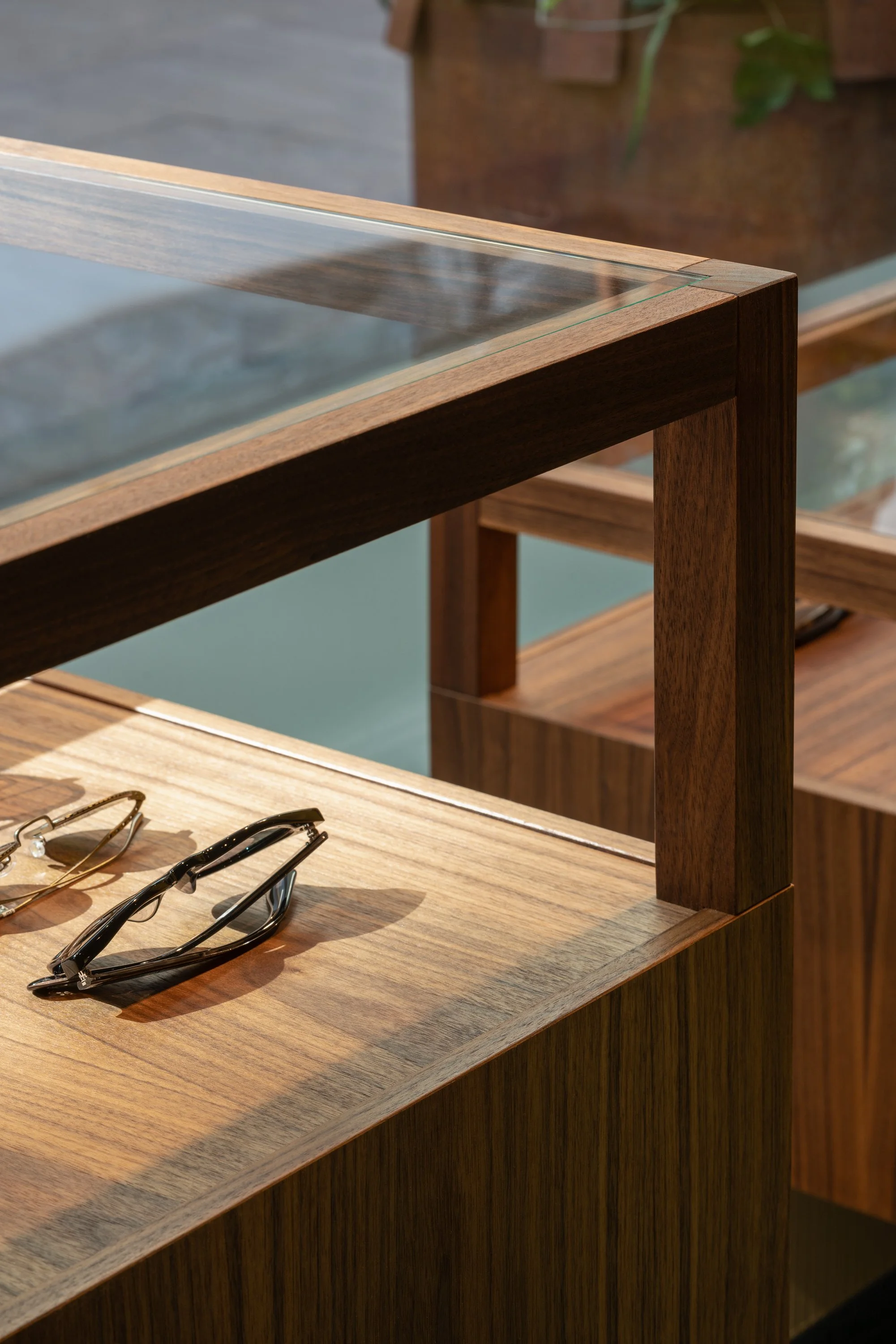 Fredsgatan Optik eyewear store in Gothenburg by Studio Navet — soft colourful textile backdrop with custom mirrors and display cabinets.