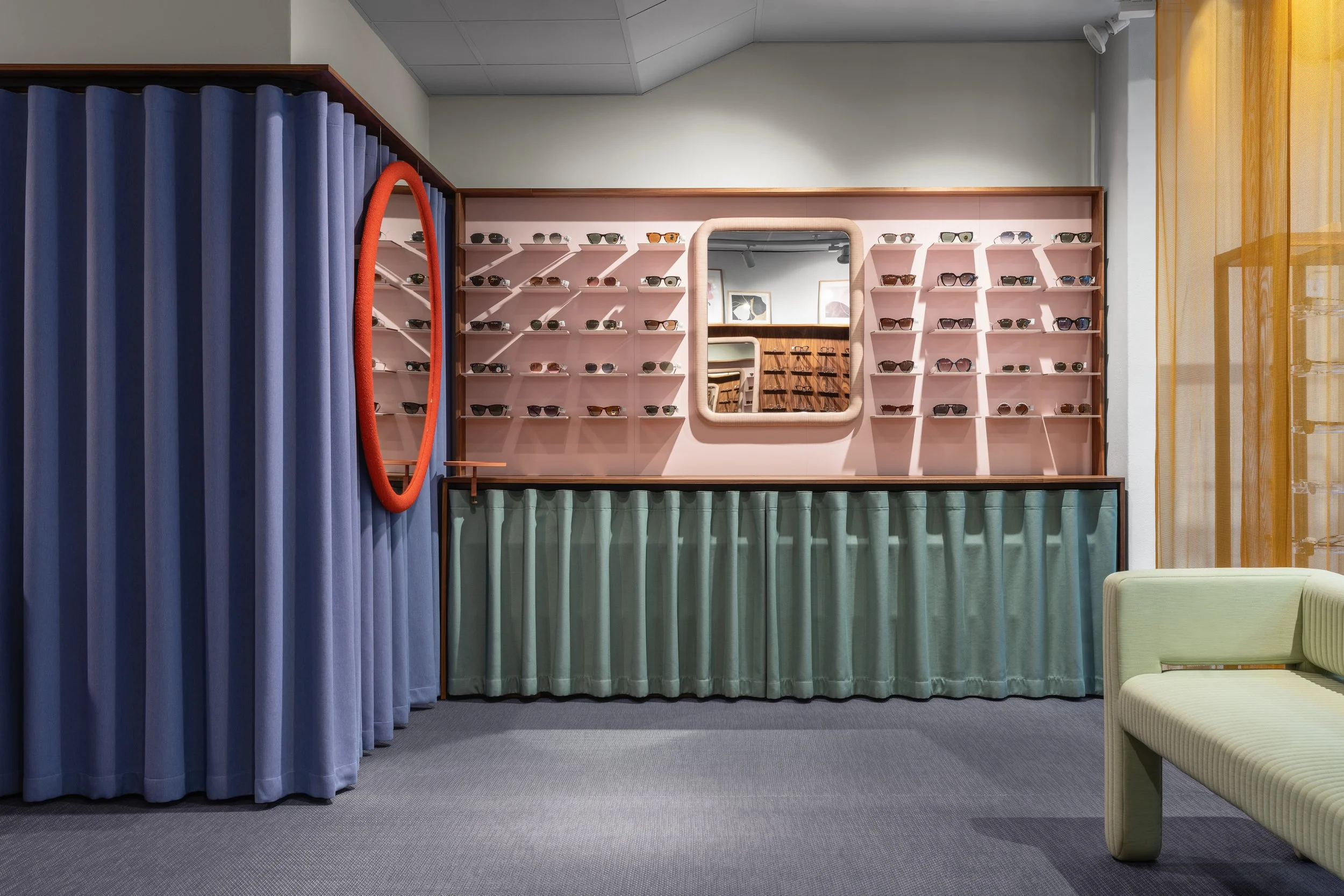 Fredsgatan Optik eyewear store in Gothenburg by Studio Navet — soft colourful textile backdrop with custom mirrors and display cabinets.