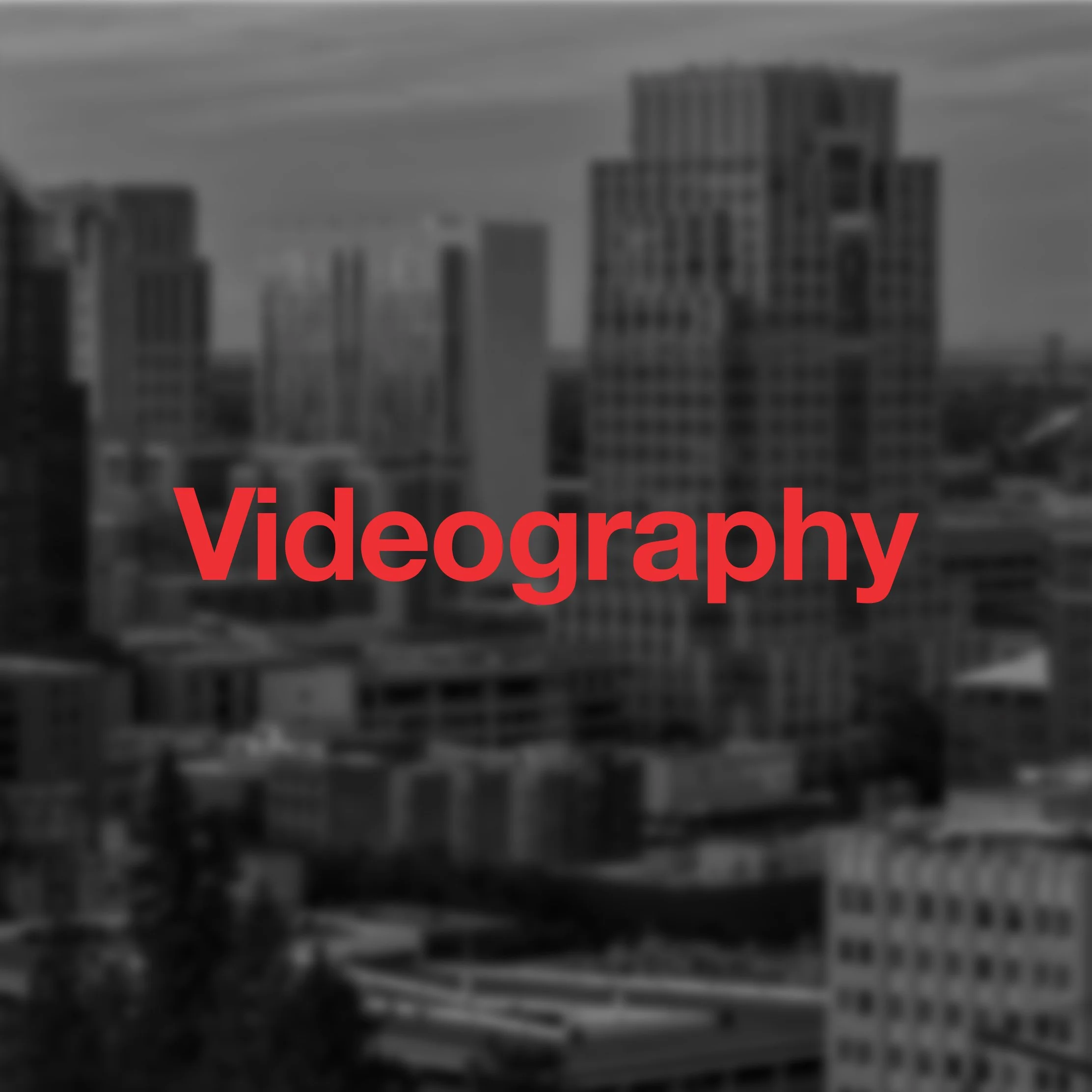 Blurred city skyline with the word 'Videography' in red text overlay.