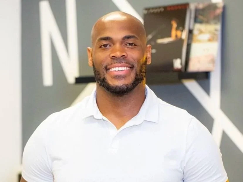 Man smiling outdoors wearing a white shirt