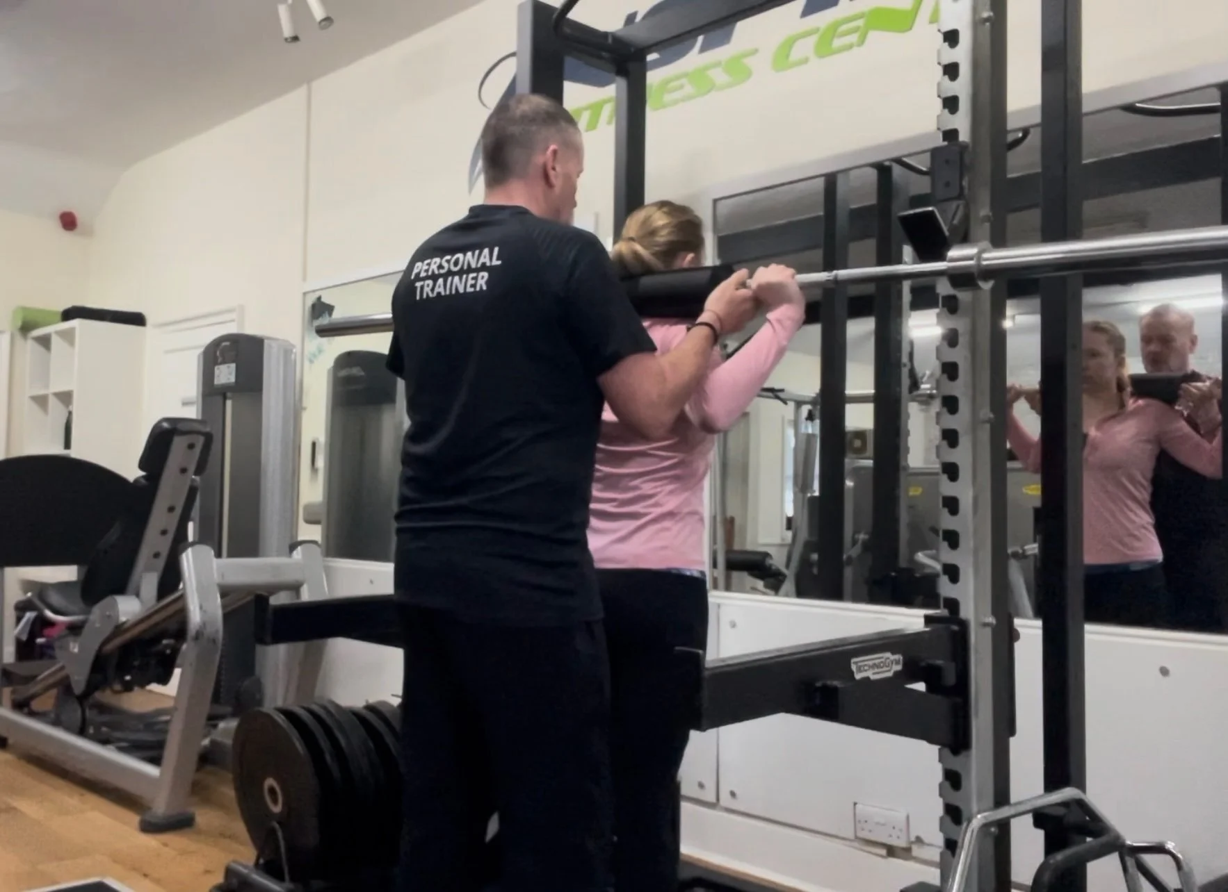 Tom Quigley Personal Trainer instructs a client on how to begin a Back Squat