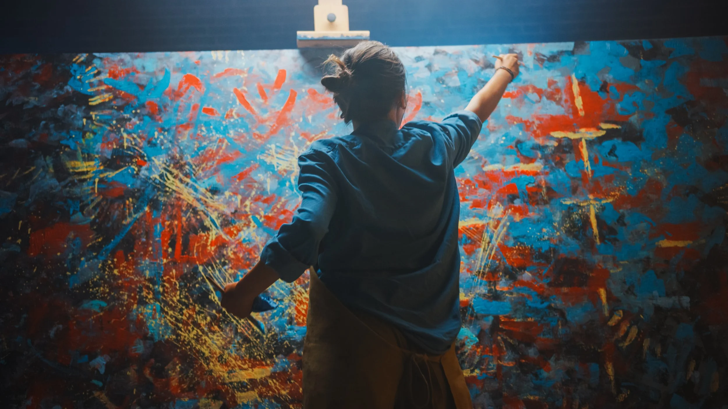 Image of an artist painting in their studio