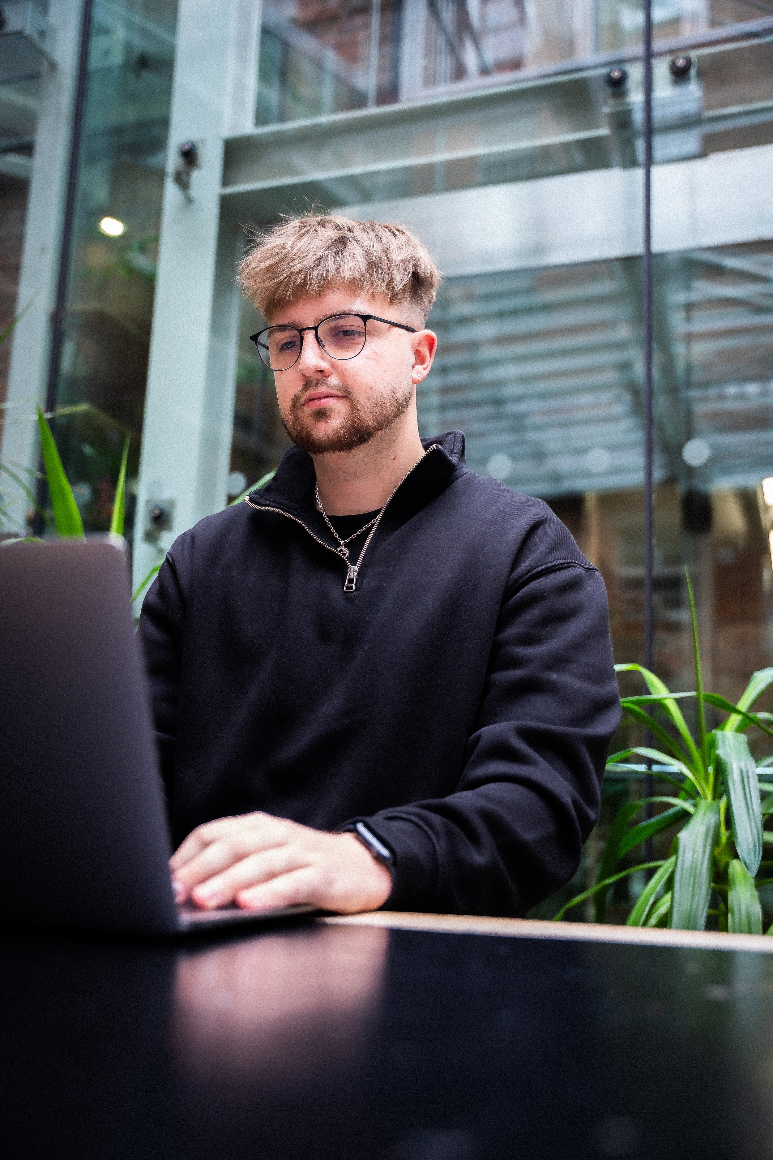 First Touch Marketing Founder, Jack Lomax, working on a laptop in a cafe in Manchester.