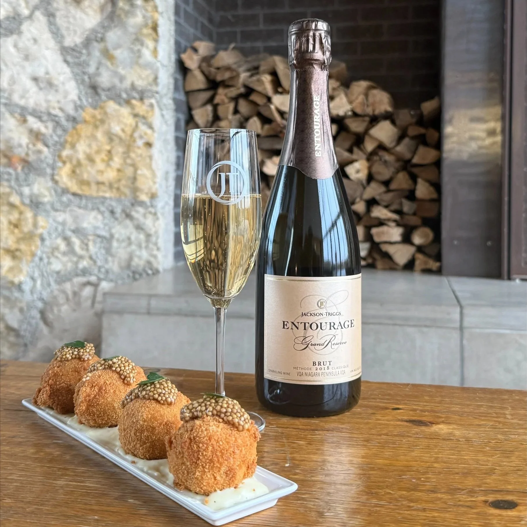 A bottle of Jackson-Triggs Vidal Icewine with two servings of beef birria nachos topped with cheese and herbs, set against a vineyard backdrop.