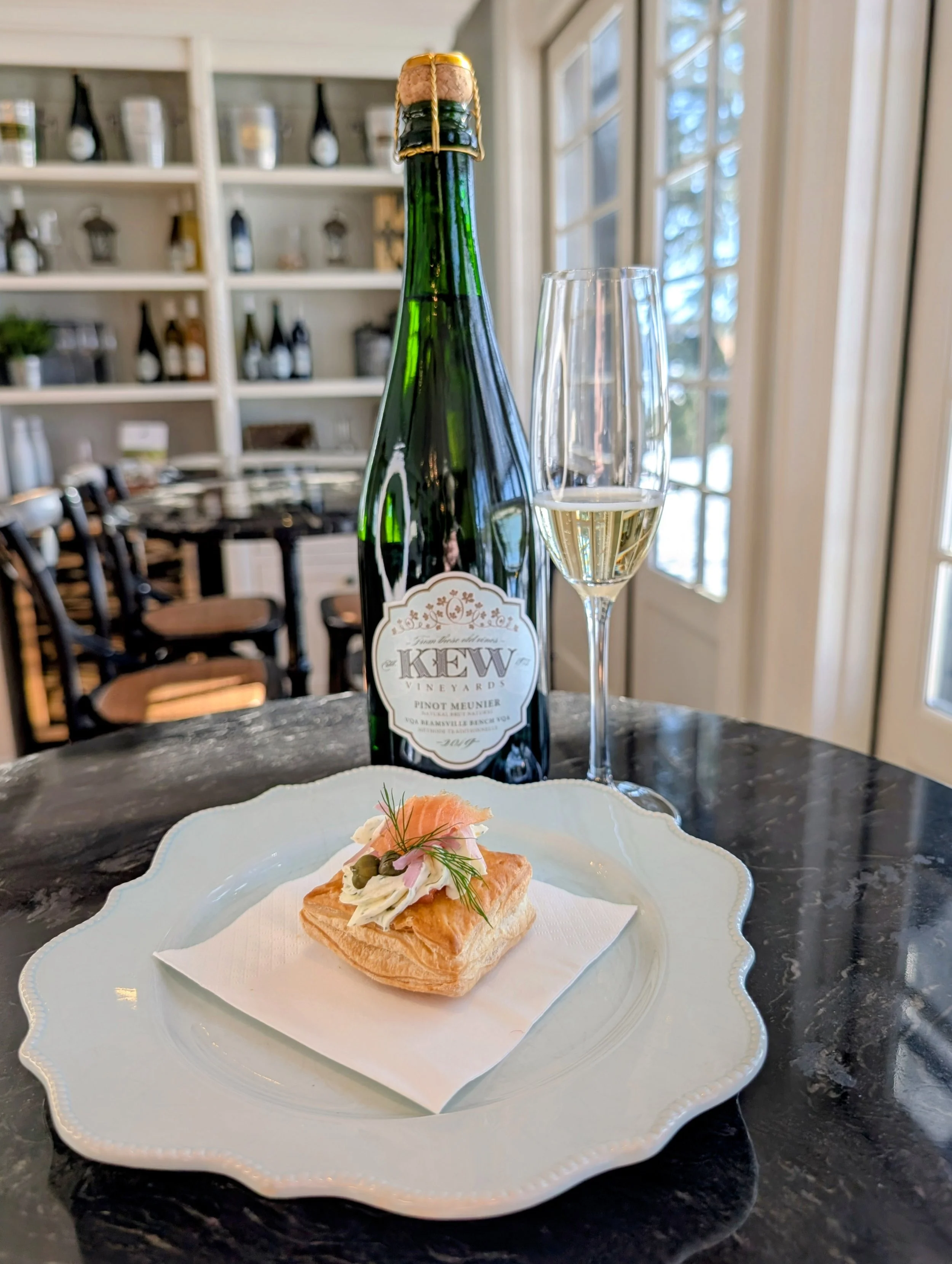 A bottle of King’s Court 2018 Late Harvest Vidal, a glass of the wine, and a crème brûlée with a caramelized sugar top.