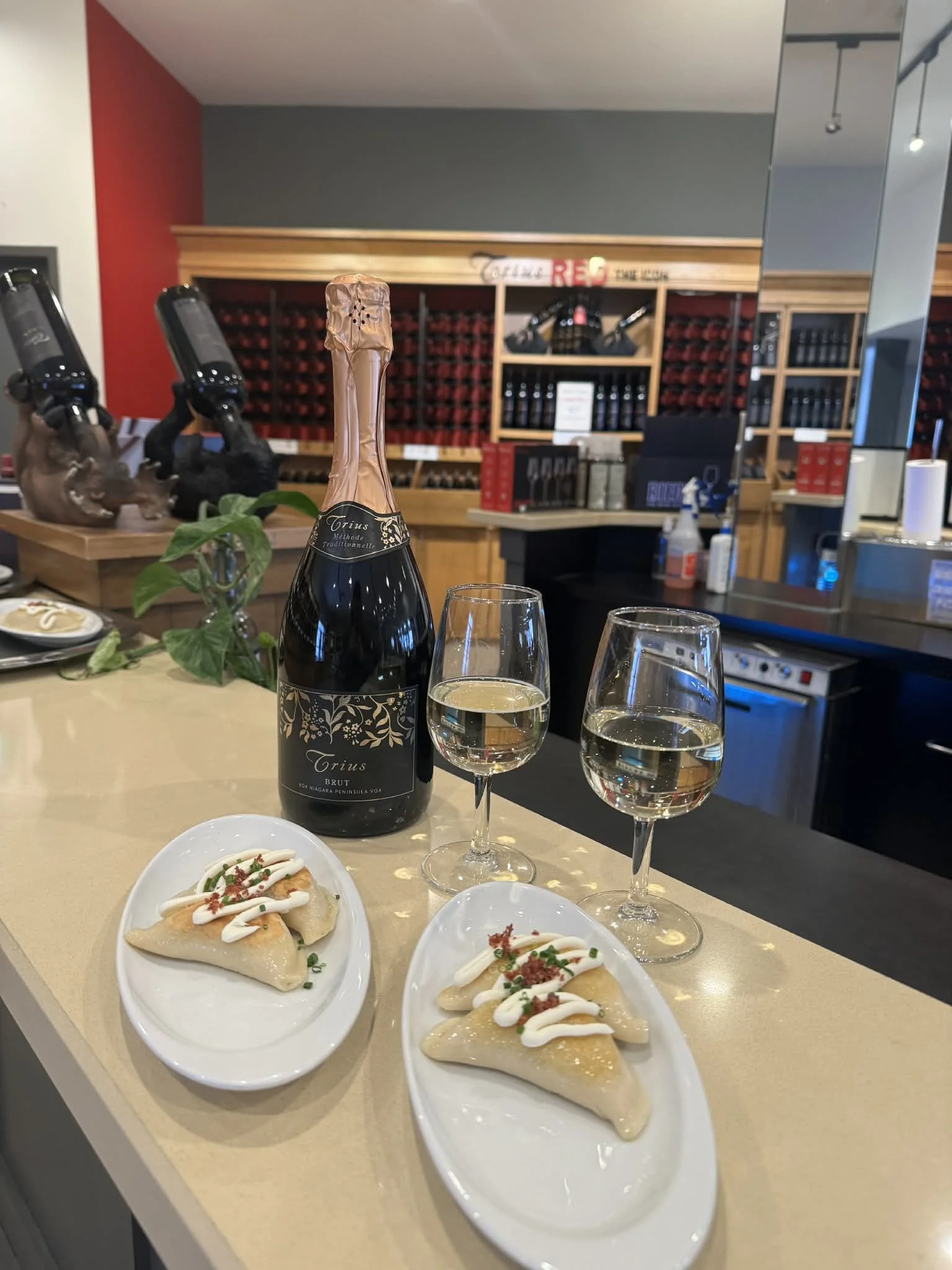 A glass of Trius Icewine next to a chocolate-covered treat in a small paper cup with a wooden pick