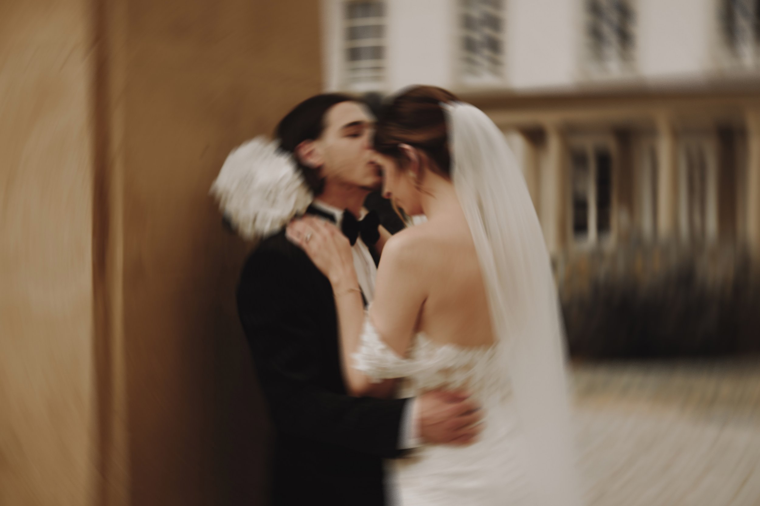 Mariage avec couple s'embrassant, vêtus de tenues de mariage élégantes.