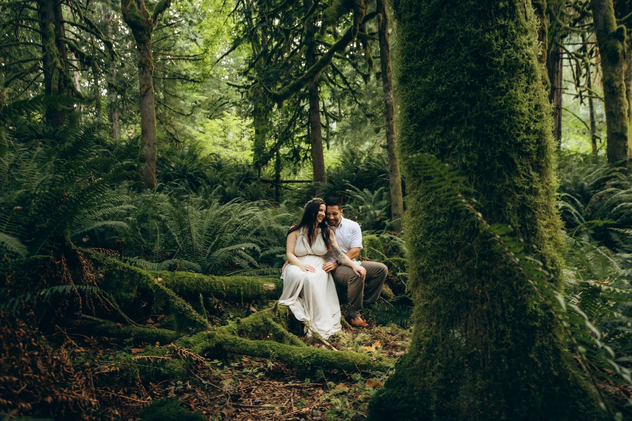 Snoqualmie Valley forest elopement in Washington with a couple sitting among mossy trees and ferns in the Pacific Northwest