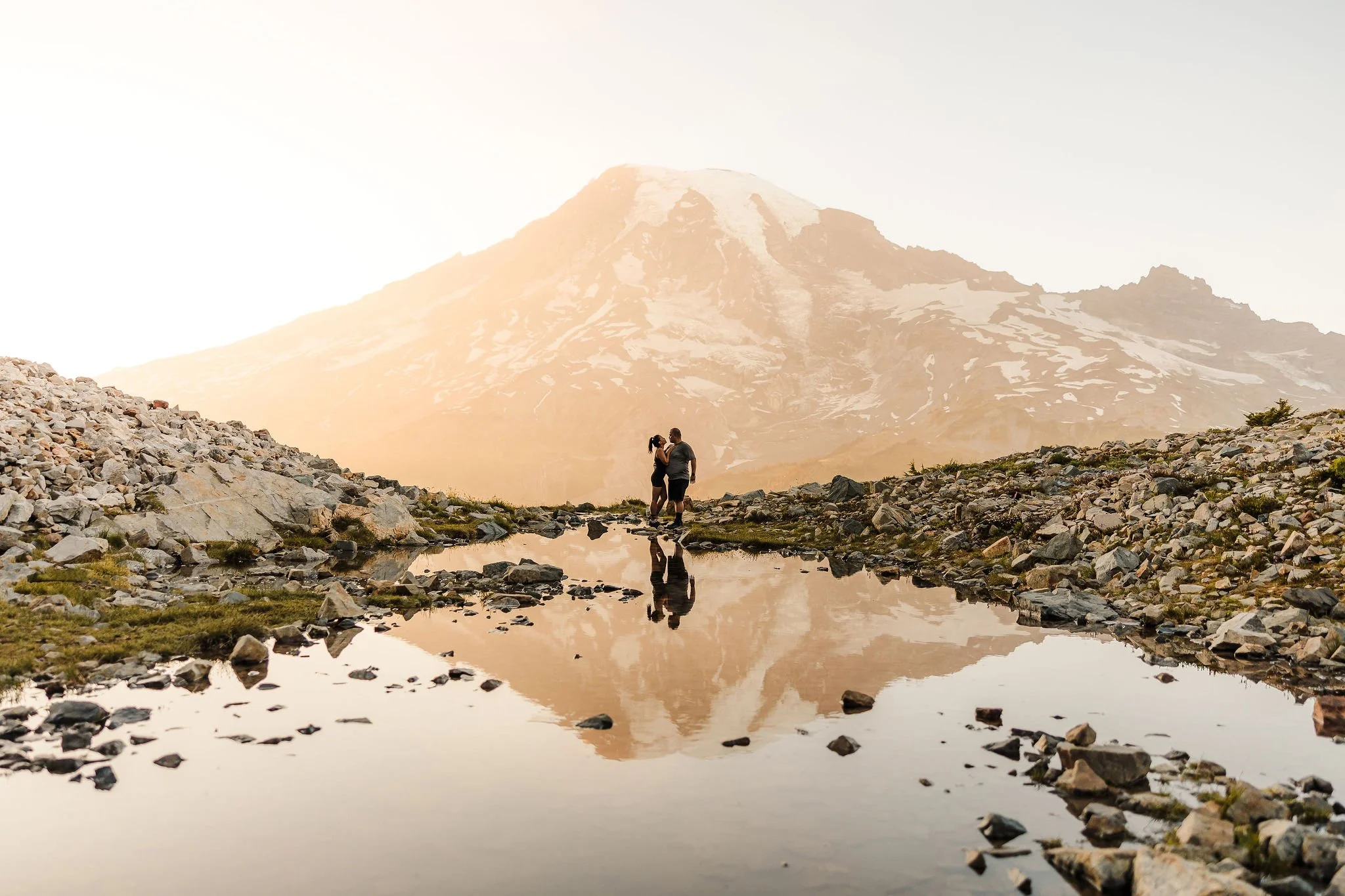 Couple eloping at sunrise near Pinnacle Peak Tarn with Mount Rainier reflected in alpine water