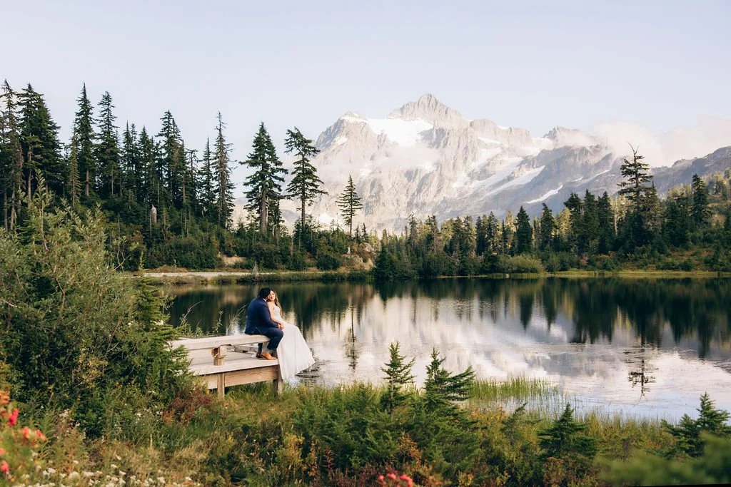 Couple sitting by Picture Lake during an elopement with Mount Shuksan reflected in the water