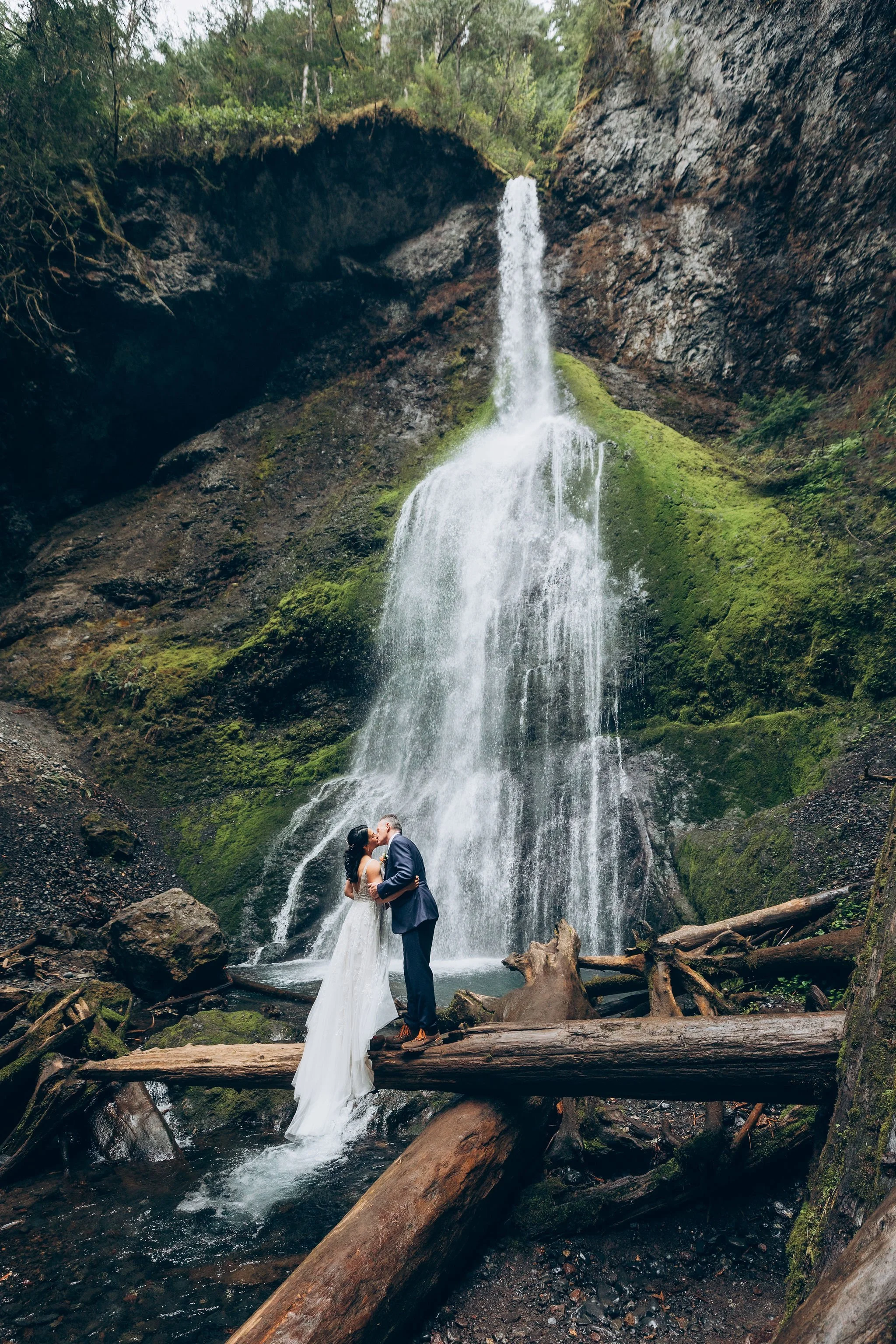 Bride wearing a lightweight elopement dress during a waterfall elopement, showing a practical wedding gown for hiking and outdoor adventures