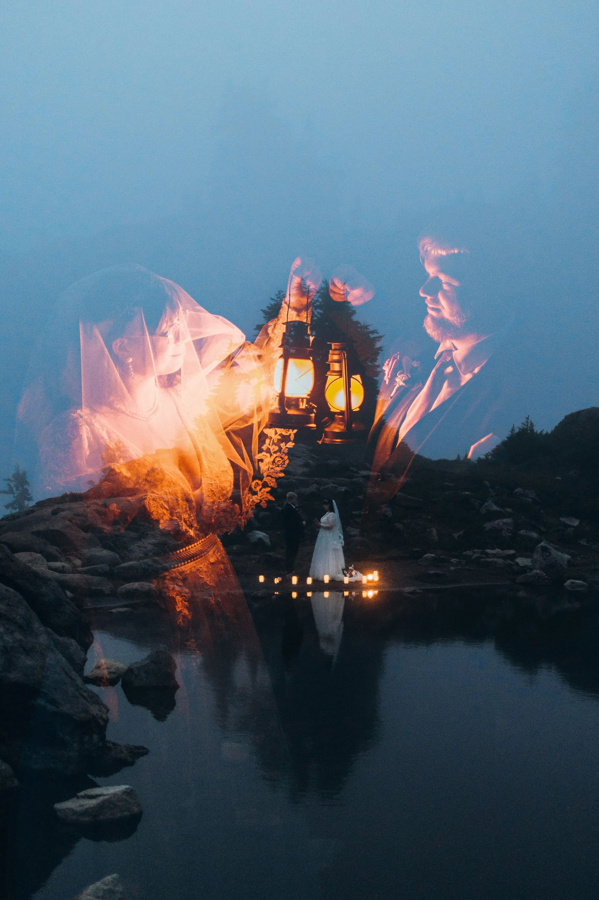 Blue hour elopement with couple holding lanterns, double exposure effect over mountain tarn reflection at dusk