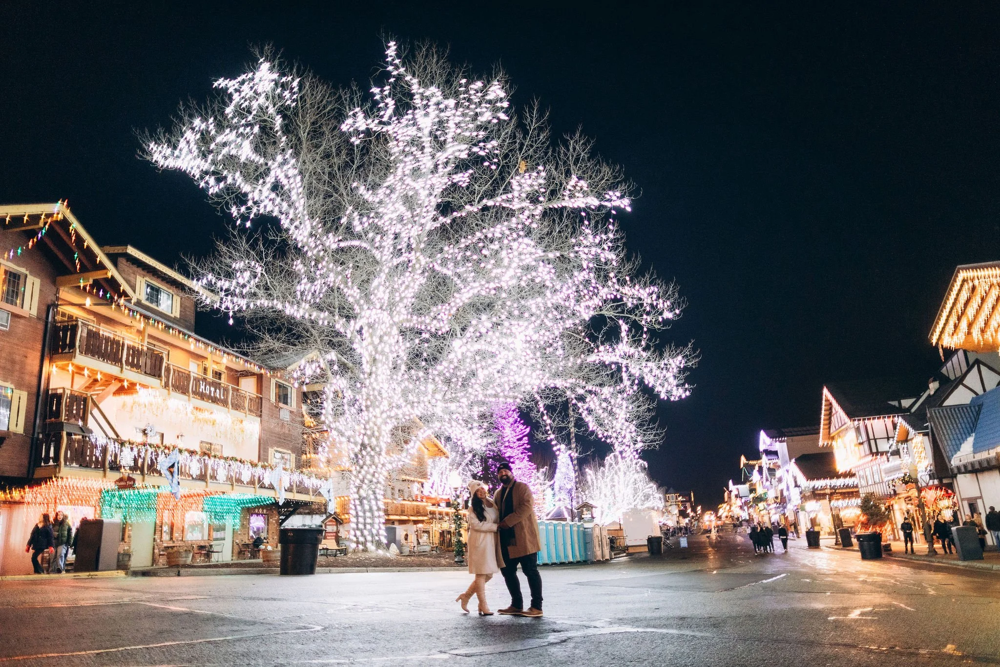 Couple standing in downtown Leavenworth during a winter elopement surrounded by Christmas lights at night