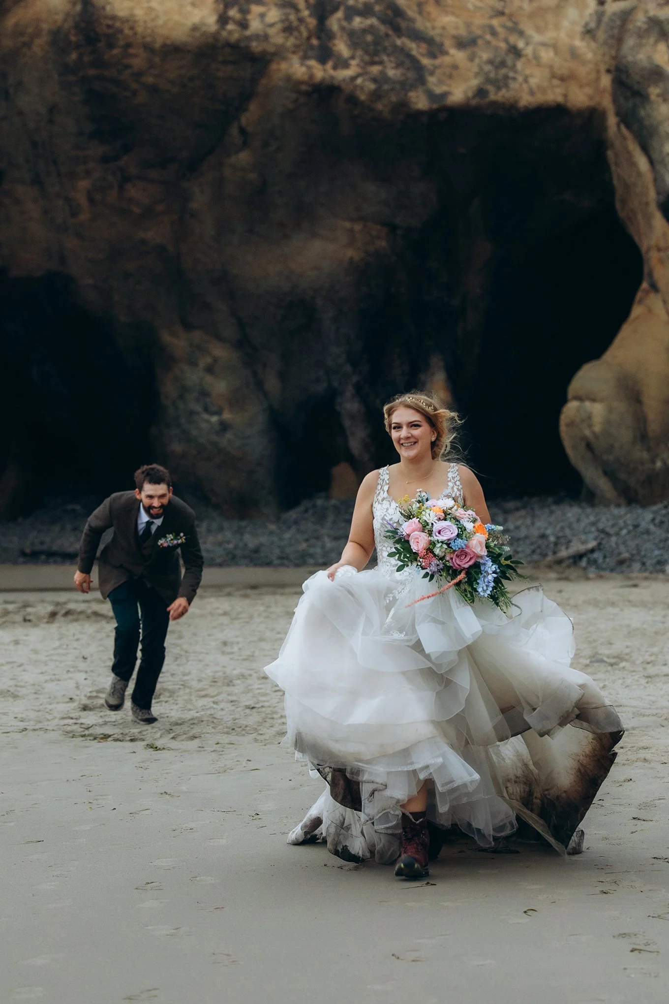 Bride running on the beach during an Oregon Coast elopement at Hug Point in the Pacific Northwest