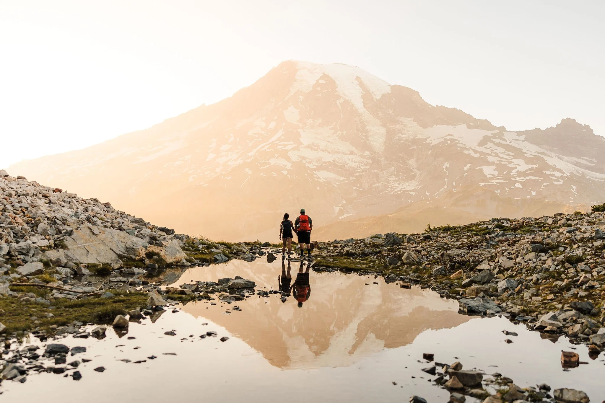 An adventurous elopement at Pinnacle Peak Tarn in the Paradise area of Mount Rainier National Park with Mount Rainier reflected in an alpine pool