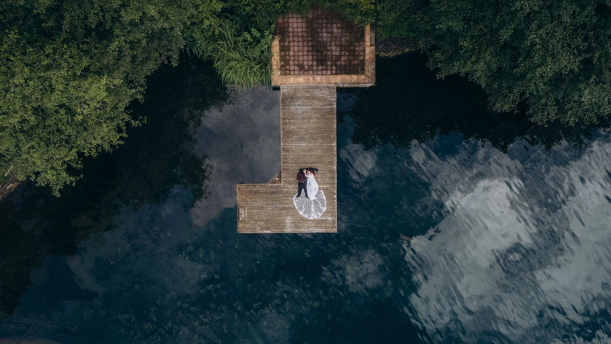 Drone shot of bride and groom on a dock at Lake Sutherland near Olympic National Park