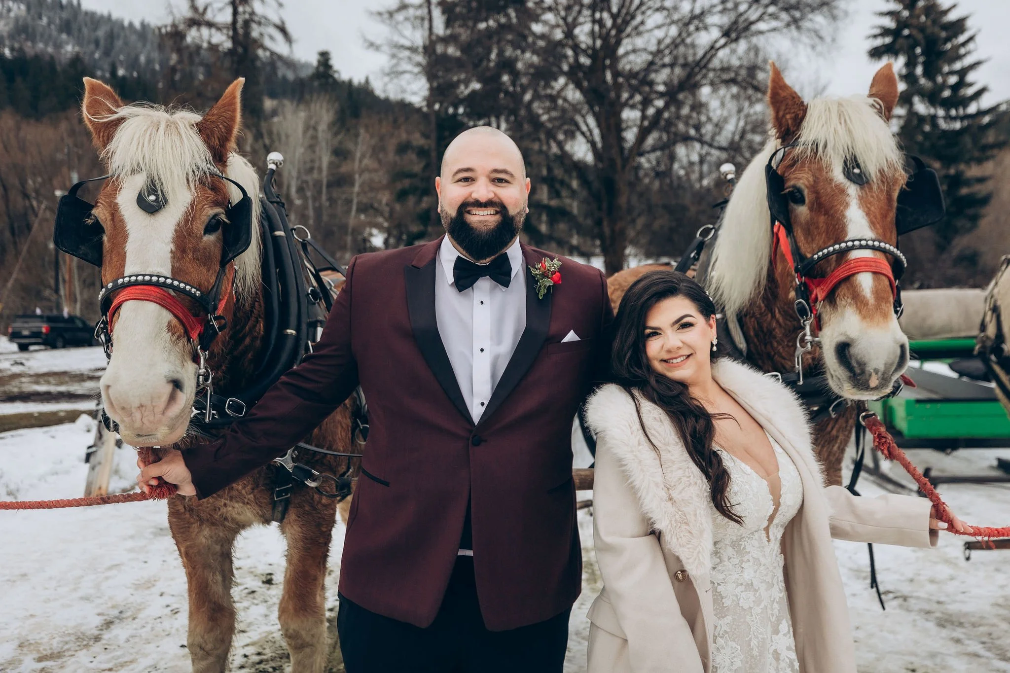 Winter snowy elopement with horses in Leavenworth, Washington, featuring a couple in wedding attire surrounded by snow
