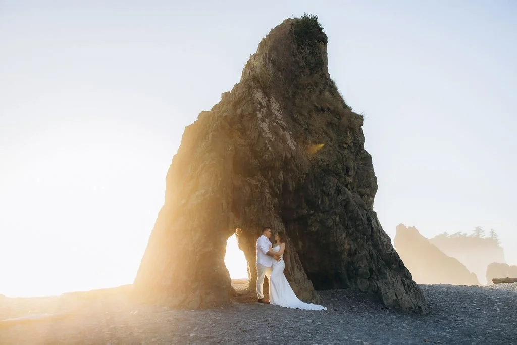 Coastal elopement at Ruby Beach, featuring a couple framed by towering rock formations and golden light