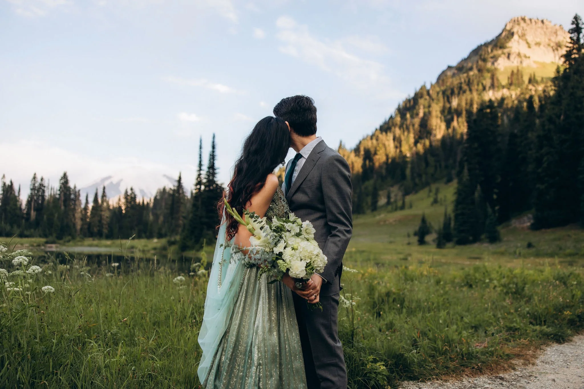 Couple eloping in Indian attire at Tipsoo Lake with Mount Rainier in the background during a summer mountain elopement